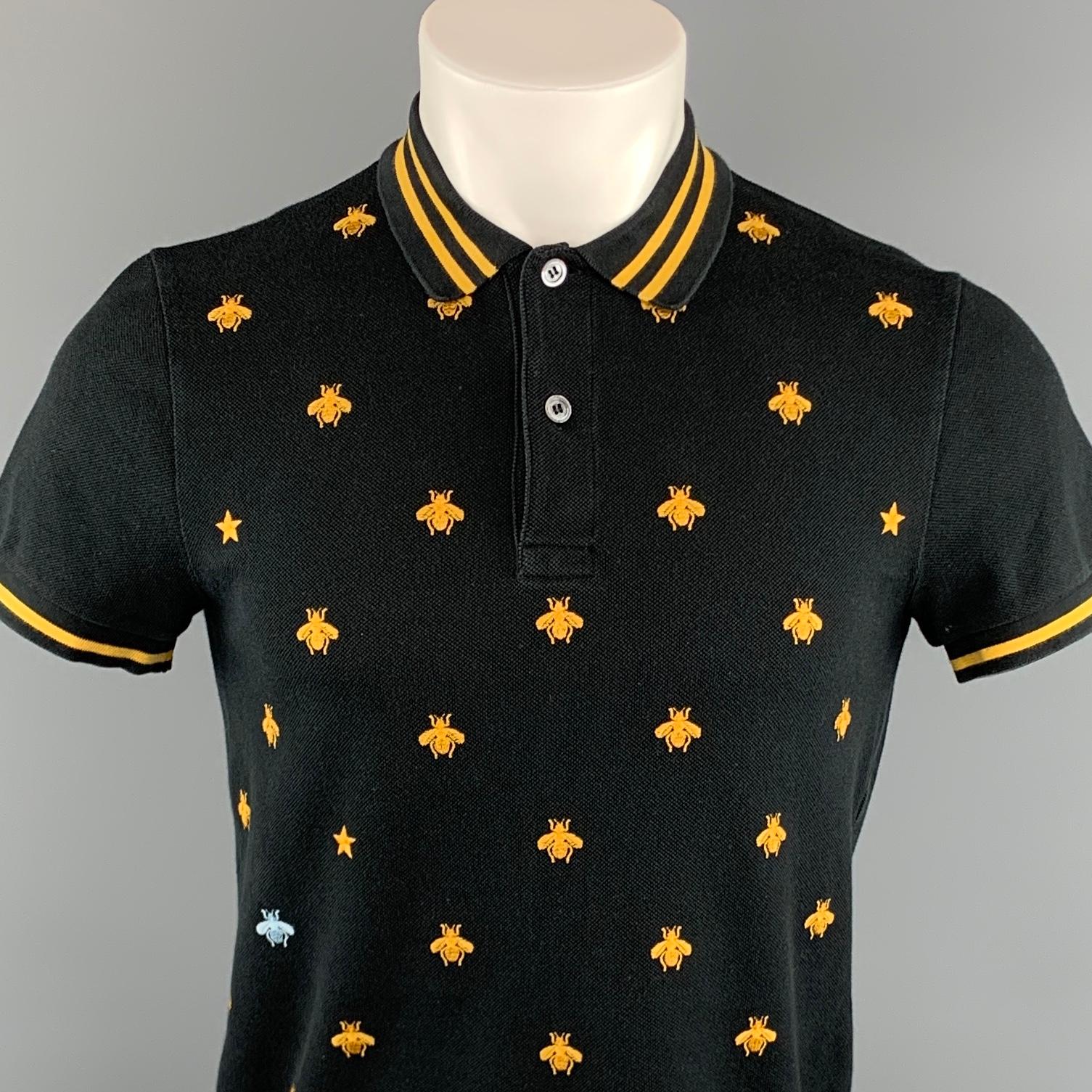 GUCCI polo comes in black cotton featuring a front all over bee embroidery pattern, stripe collar trim detail, and a buttoned closure. Made in Italy.
 
Very Good Pre-Owned Condition.
Marked: S
 
Measurements:
 
Shoulder: 17.5 in.
Chest: 41