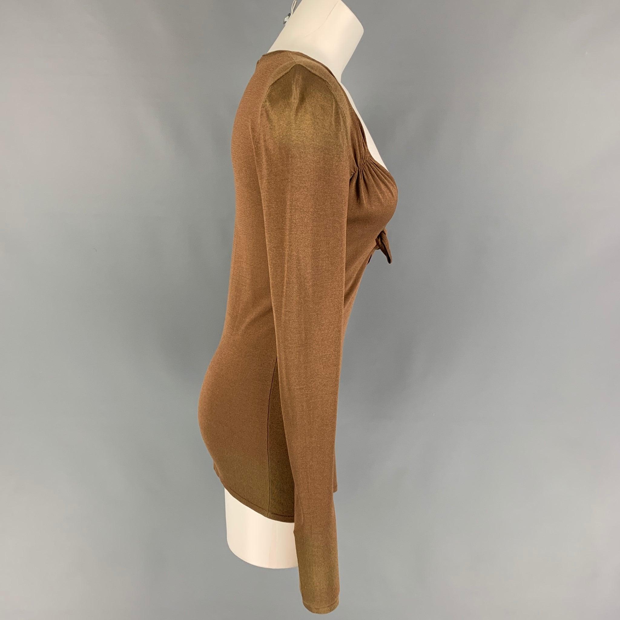 GUCCI pullover comes in a copper silk blend featuring a deep v-neck, front self-tie detail, and long sleeves. Made in Italy.
Good
Pre-Owned Condition. Moderate discoloration at right shoulder, right sleeve, and right hem. As-Is.  

Marked:   S