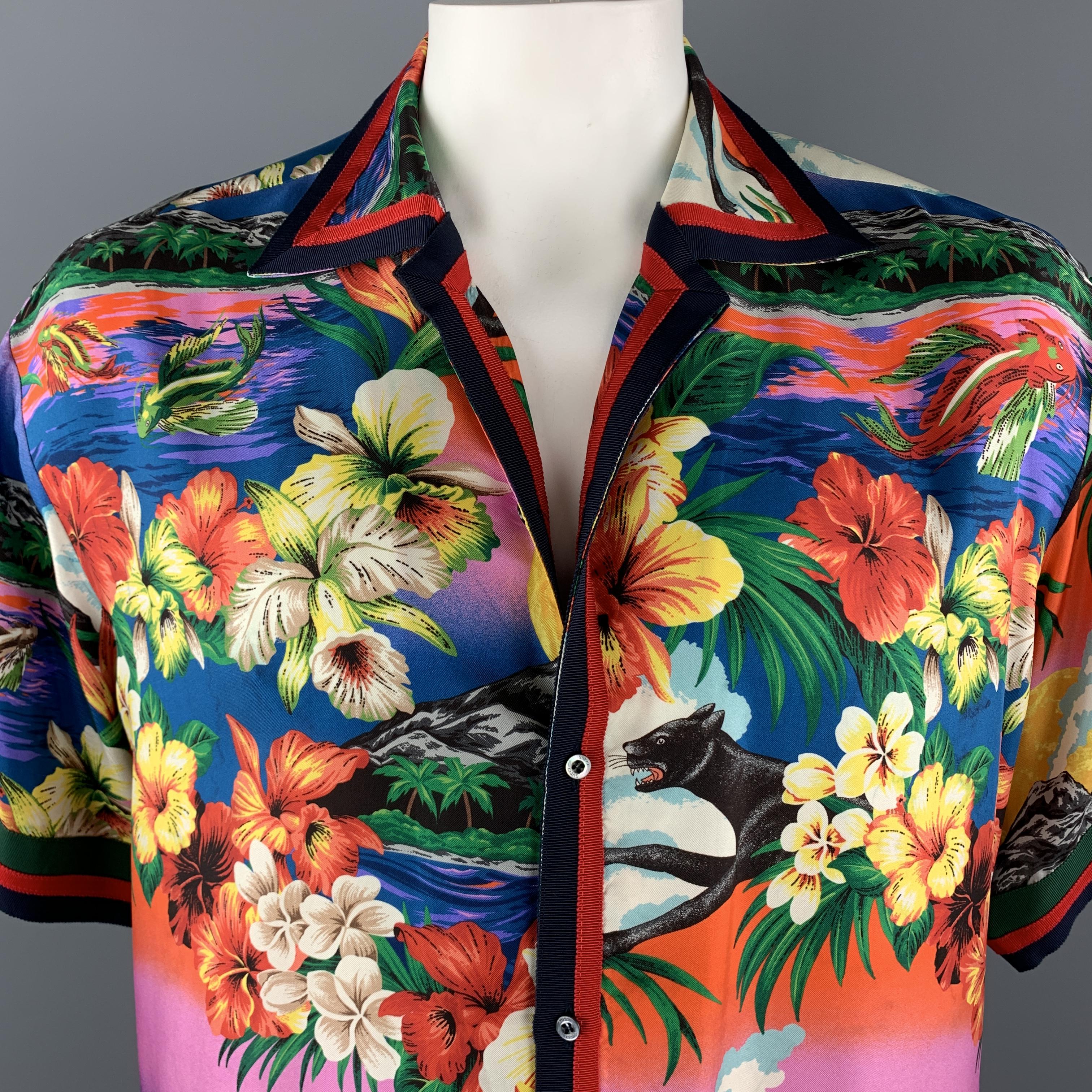 GUCCI Hawaiian resort shirt comes in a colorful silk twill with an all over floral, volcano, panther, and fish print , short sleeves, and red, navy, and green striped ribbon trim. Faint discolorations throughout. As-is. Matching shorts sold