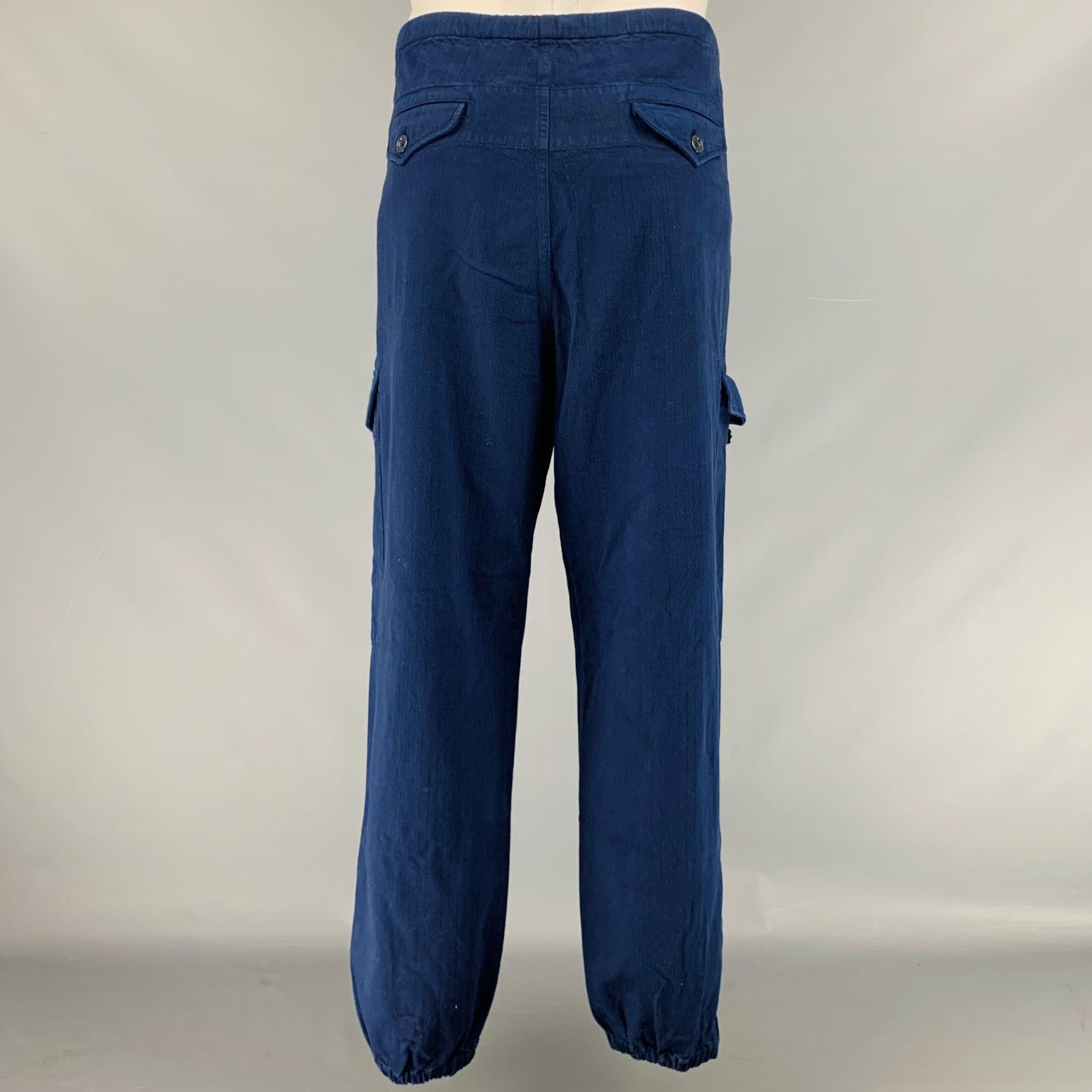 Pantalon décontracté Gucci
en coton bleu marine, avec de grandes poches latérales plaquées, un cordon de serrage à la taille, des poignets élastiques zippés et une braguette boutonnée. Fabriqué en Italie. Très bon état. Signes mineurs d'usure.