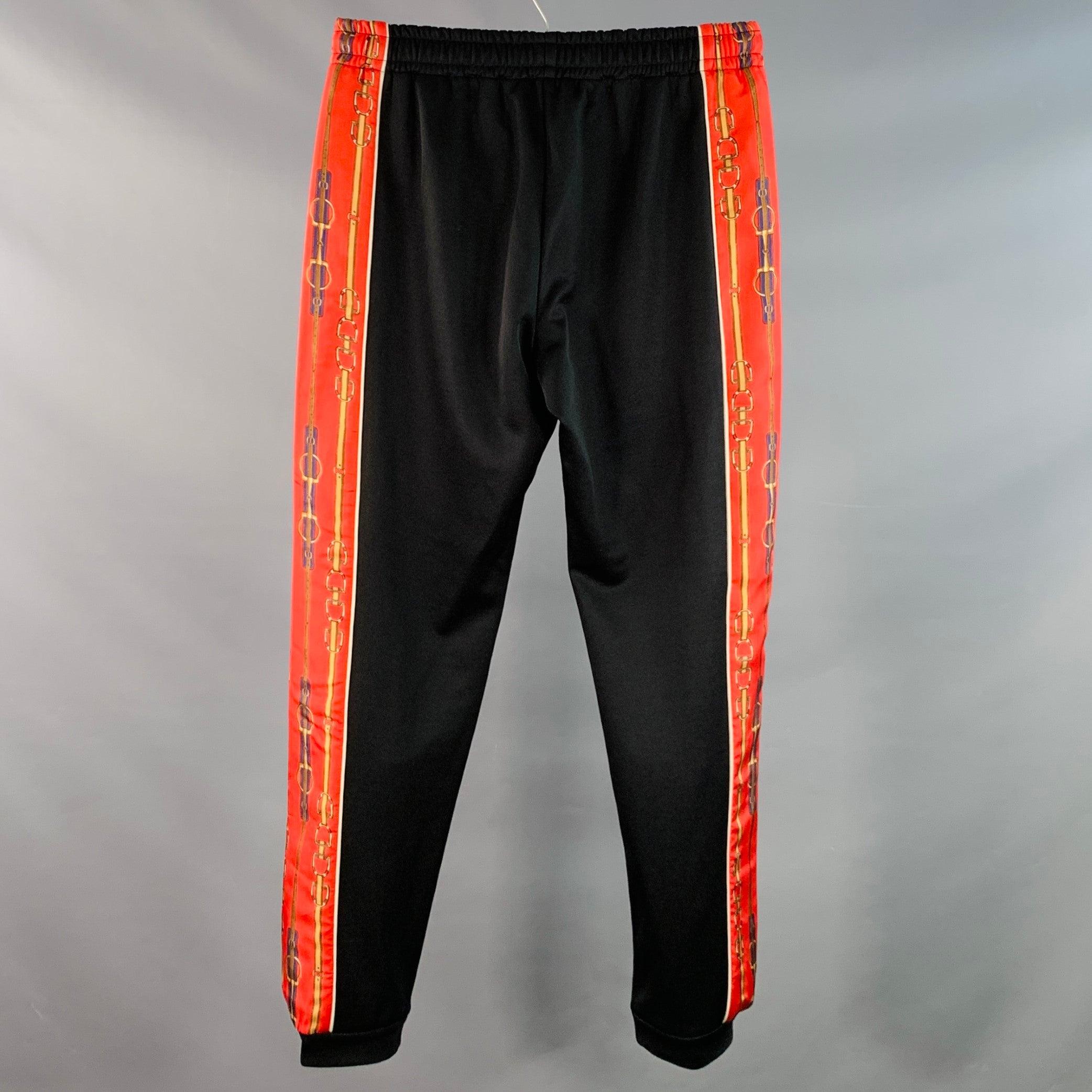 GUCCI Freizeithose
aus schwarzem Polyester-Baumwoll-Gemisch mit seitlichen Streifen in Rot und Gold, im Jogging-Stil und mit Kordelzug am Bund. Made in Italy. sehr guter gebrauchter Zustand. Leichte Gebrauchsspuren. 

Markiert:   XS 

Abmessungen: 
