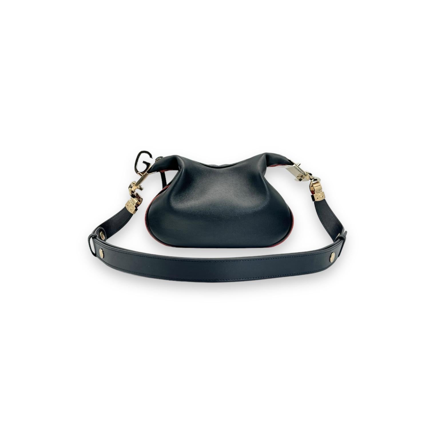 Elevate your style with the Gucci Small Attache Black Leather Crossbody Bag. Crafted in Italy with premium black leather, this bag features a spacious single zip compartment with a luxurious gold-tone zipper closure. The addition of an adjustable