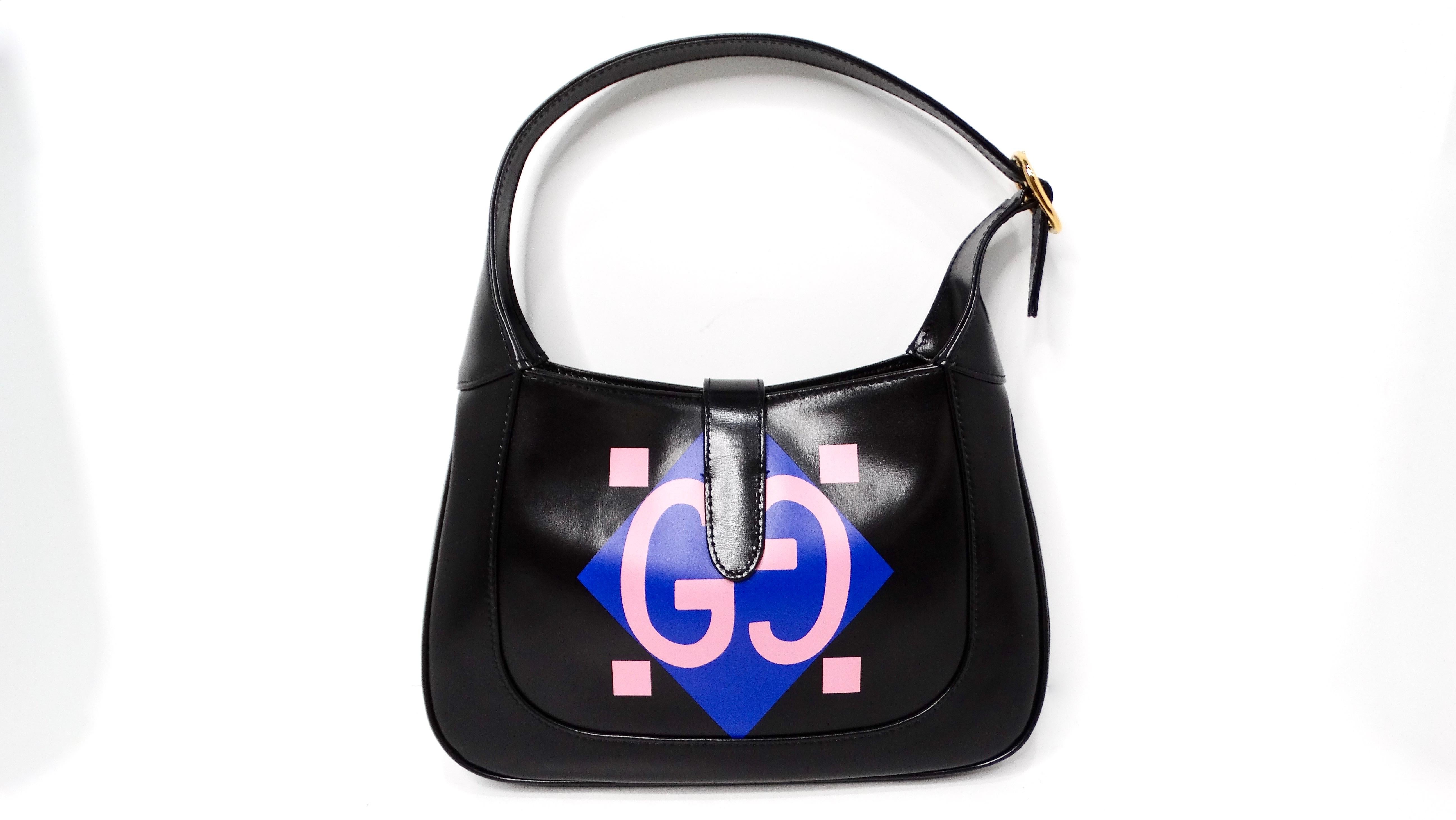 The Gucci Small Jackie 1961 Black Calfskin Multicolor Geometric Logo Print Hobo Bag embodies a perfect blend of modern style and vintage flair. Crafted from luxurious black calfskin leather, this chic bag features a distinct geometric logo print