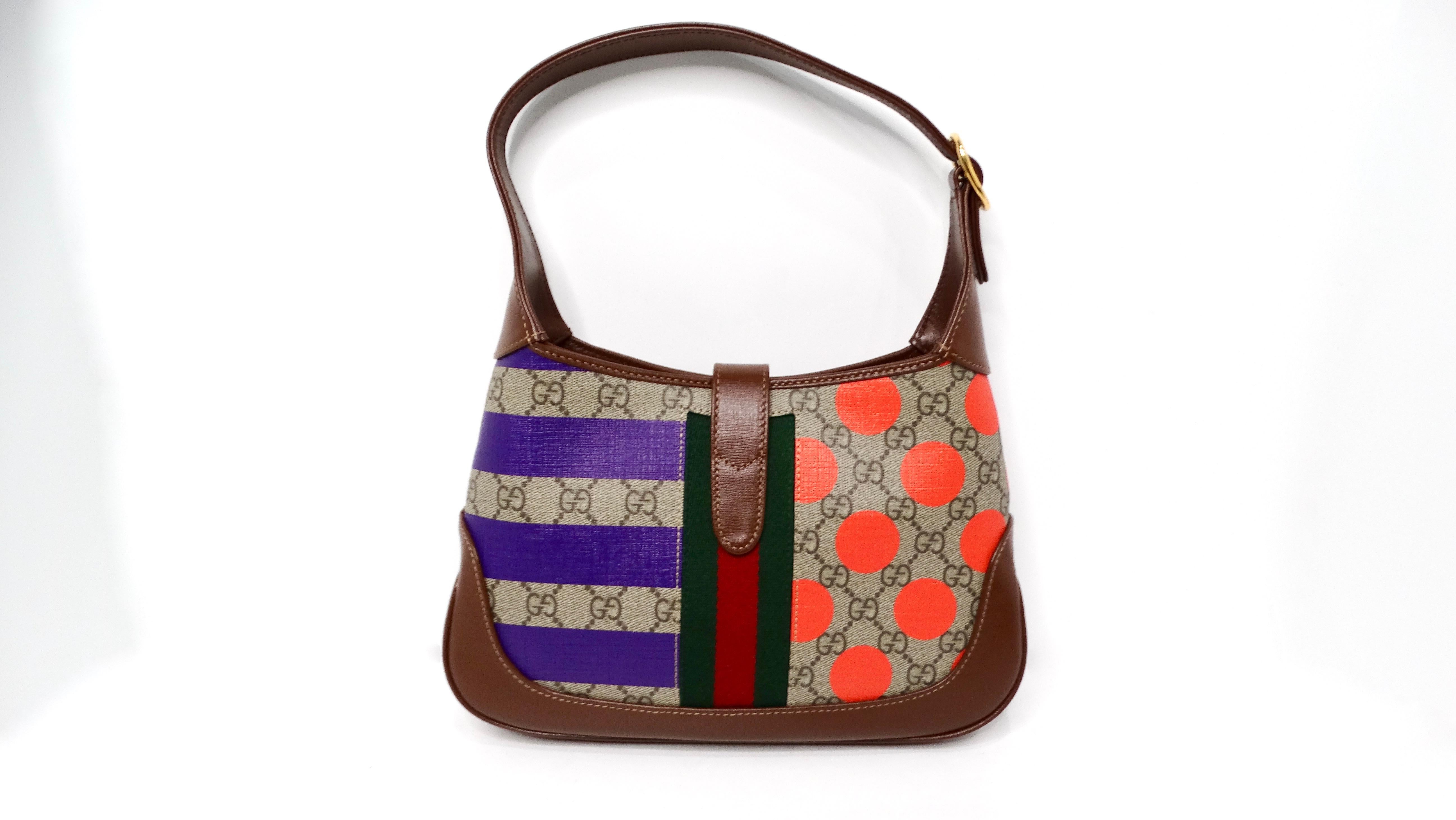 The Gucci Small Jackie 1961 GG Supreme Monogram Calfskin Multicolor Print Hobo Bag perfectly juxtaposes classic elegance with contemporary flair, making it a must-have for the modern fashionista. Crafted from smooth brown calfskin leather, the bag's