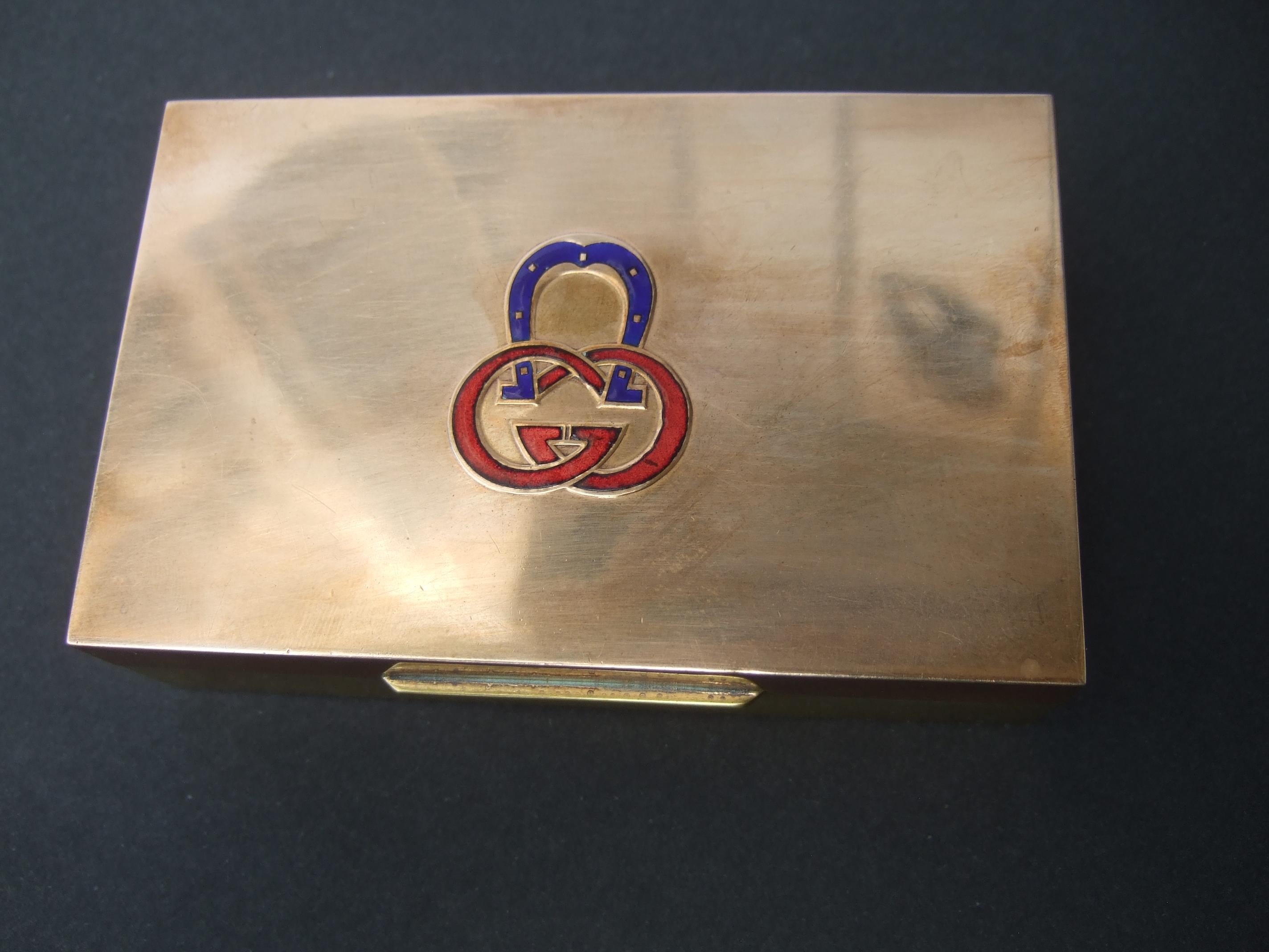 GUCCI Small mixed metal cloisonne' enamel trinket box c 1970s
The small mixed metal box is designed with Gucci's iconic interlocked G.G. 
cloisonne' initials on the hinged lid cover 

The lid cover is copper metal. The base of the small box is brass