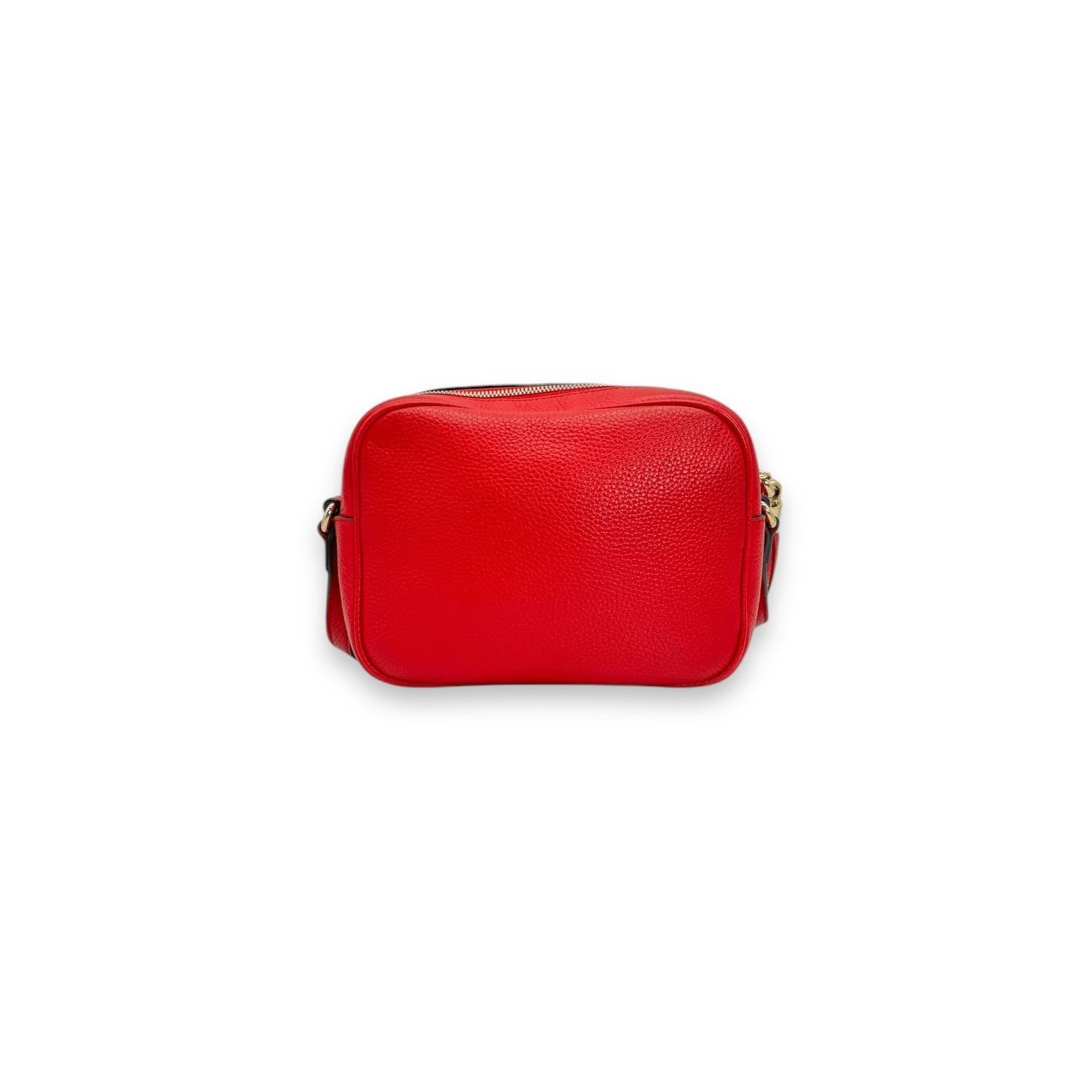 The Gucci Small Soho Disco Red Crossbody Bag is a luxurious accessory that exudes sophistication. Made from red pebbled calfskin leather, it features a zip closure, gold-tone hardware, and a canvas lining with a single interior pocket. With its