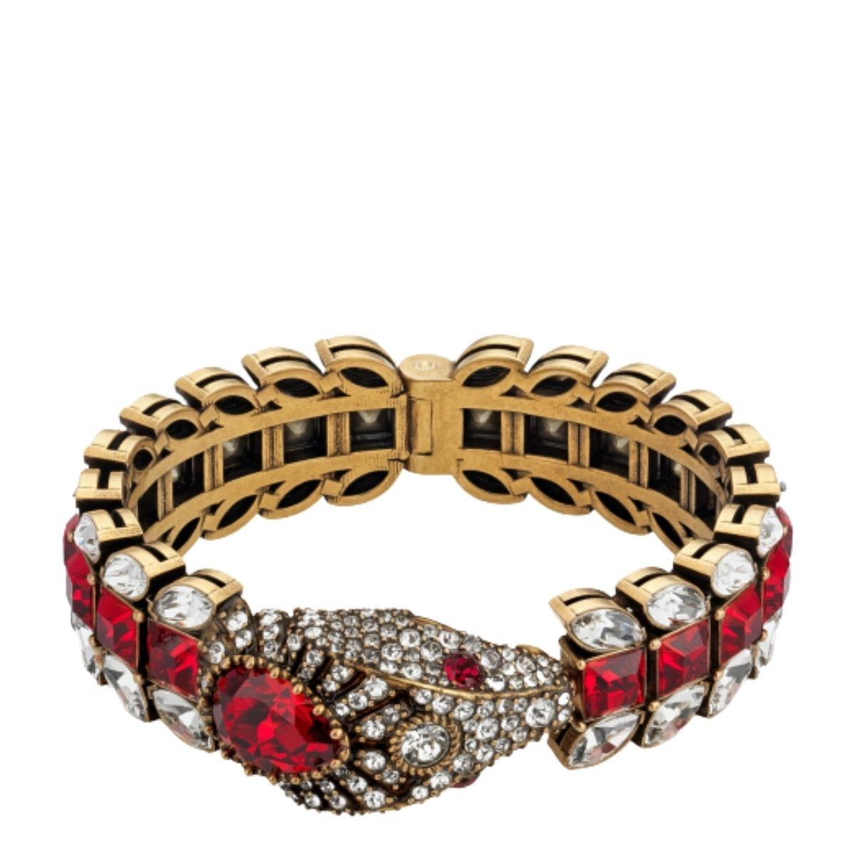 Bracelet en or avec un motif serpent de Gucci. 
Incrustée d'éléments décoratifs de couleur argentée et rouge.
Conception structurée
Métal de couleur or et embellissements en cristal.
Composition : Cristal, métal
Largeur : 0.8