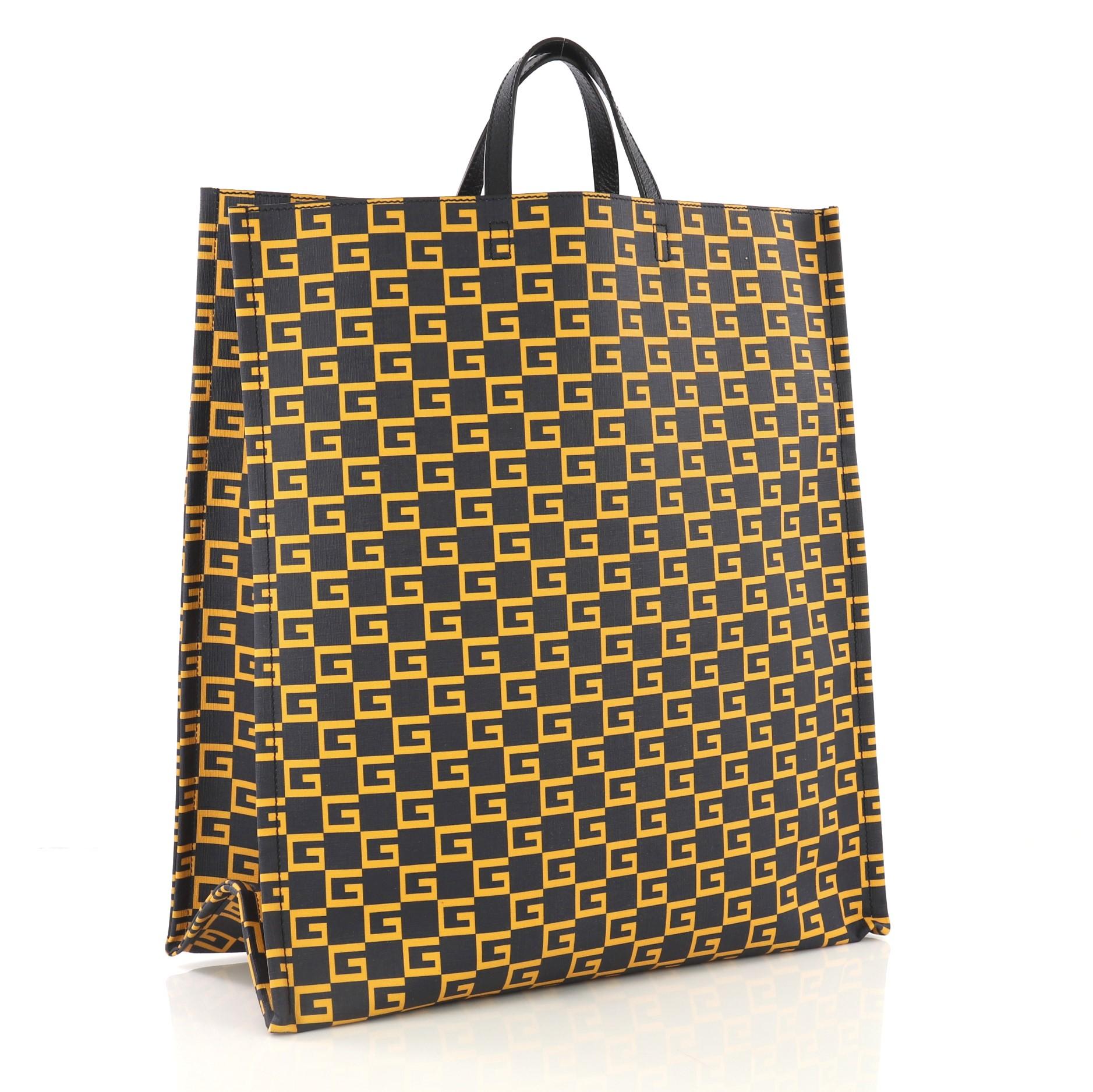 This Gucci Soft Open Tote Printed Coated Canvas Tall, crafted in navy and yellow printed coated canvas, features dual flat leather handles. It opens to a navy fabric interior. 

Estimated Retail Price: $980
Condition: Excellent. Minor wear on base