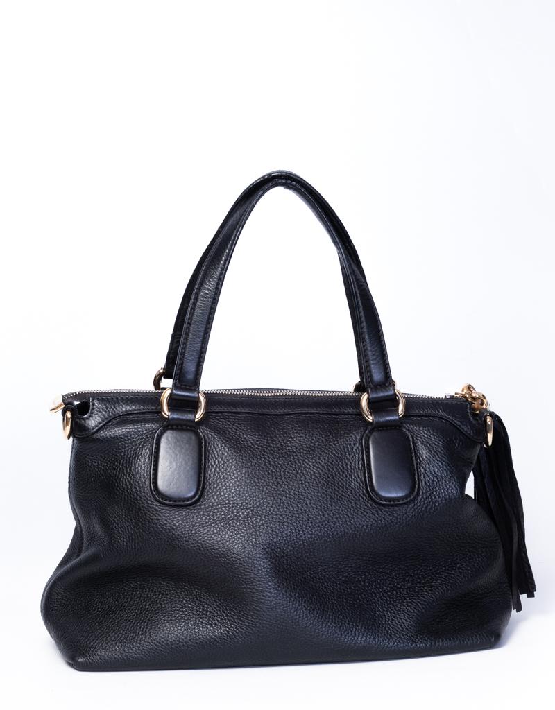 This tote bag by Gucci is made of pebbled calfskin leather and features a leather strap top handles with brass links, an optional leather shoulder strap, a hanging brass knob tassel and a large facing interlocking quilted GG.

COLOR: Black
MATERIAL:
