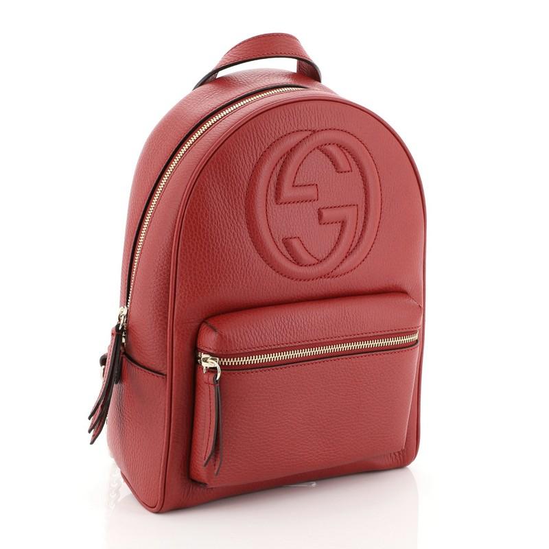 This Gucci Soho Chain Backpack Leather, crafted in red leather, features a top leather handle, chain link strap, exterior front zip pocket, and gold-tone hardware. Its zip closure opens to a neutral fabric interior with slip pockets. 

Estimated