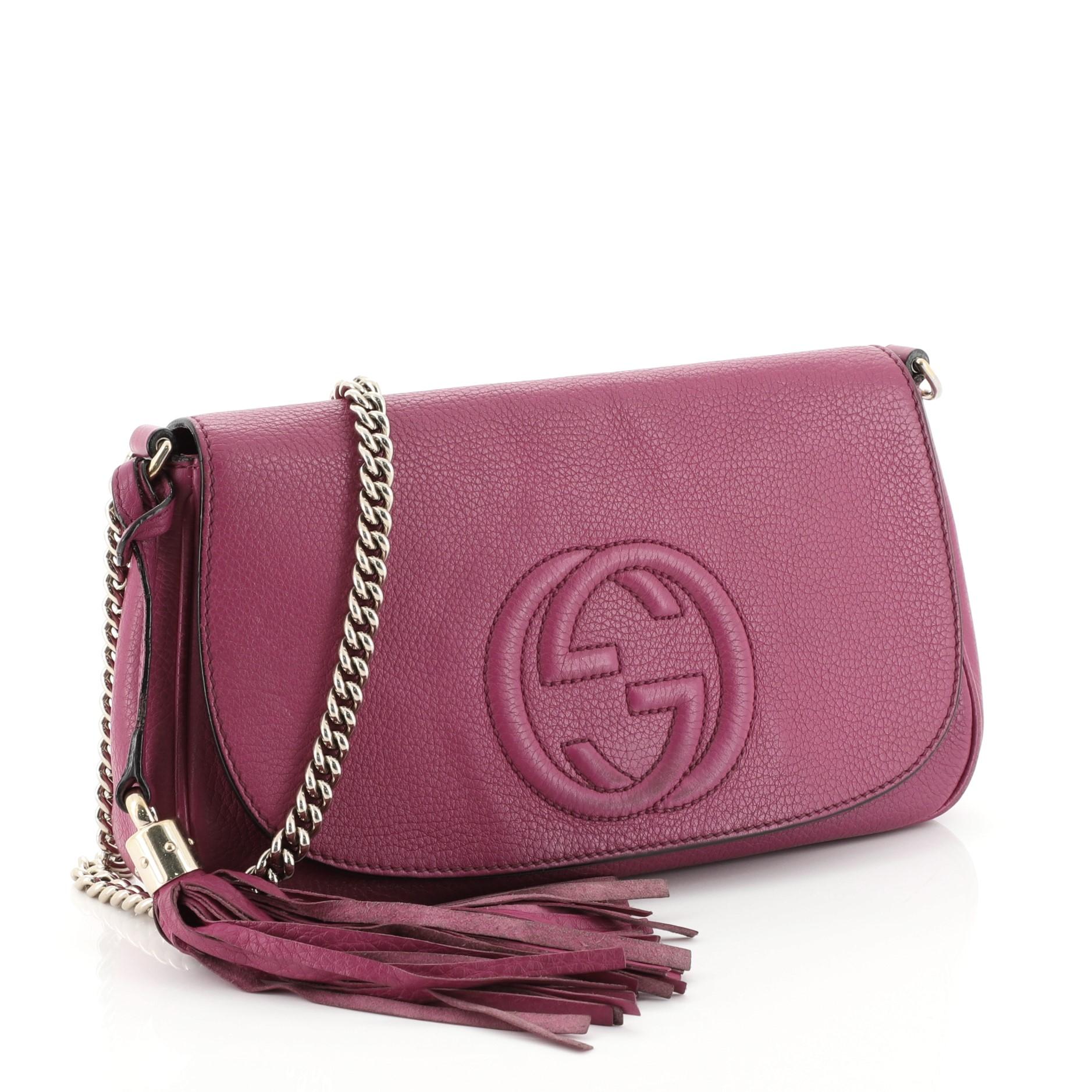This Gucci Soho Chain Crossbody Bag Leather Medium, crafted from pink leather, features a long chain strap, stitched interlocking GG logo on its flap, and gold-tone hardware. Its hidden magnetic snap closure opens to a neutral fabric interior with