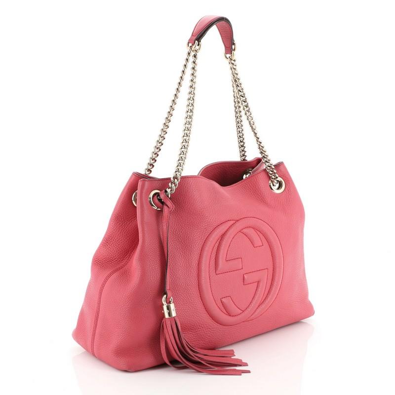 This Gucci Soho Chain Strap Shoulder Bag Leather Medium, crafted in pink leather, features chain link straps with leather pads and gold-tone hardware. Its hook clasp closure opens to a neutral fabric interior with side zip and slip pockets.