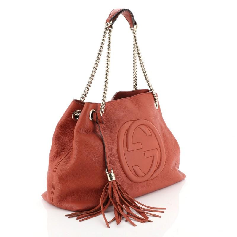 This Gucci Soho Chain Strap Shoulder Bag Leather Medium, crafted in red leather, features chain link straps with leather pads and gold-tone hardware. Its hook clasp closure opens to a neutral fabric and canvas interior with side zip and slip