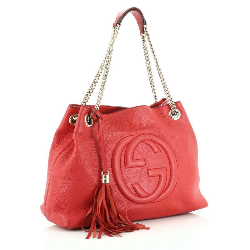 This Gucci Soho Chain Strap Shoulder Bag Leather Medium, crafted in red leather, features chain link straps with leather pads and gold-tone hardware. Its hook clasp closure opens to a neutral fabric interior with side zip and slip pockets.