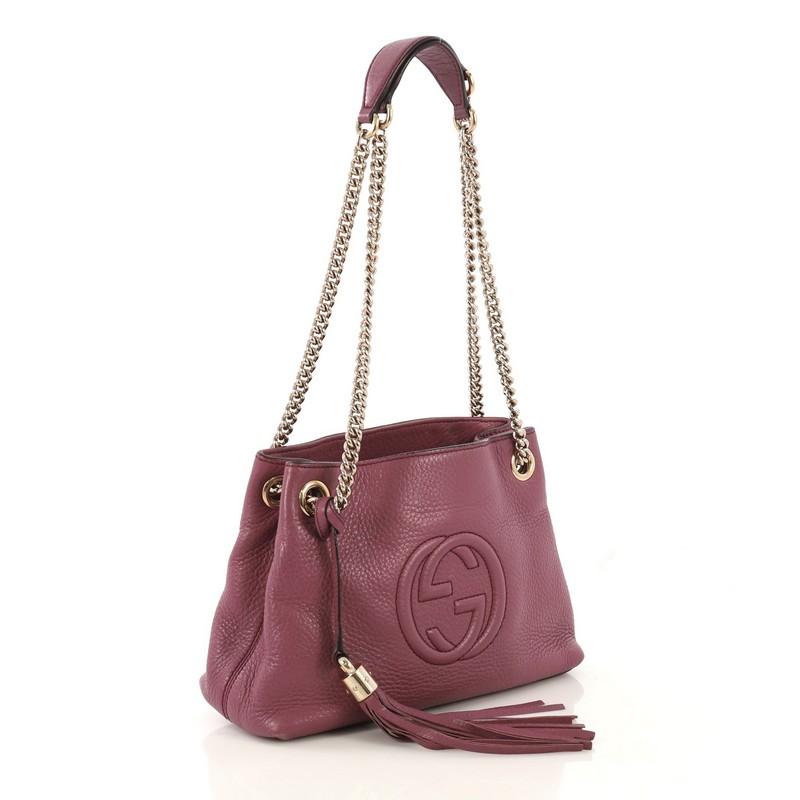 This Gucci Soho Chain Strap Shoulder Bag Leather Mini, crafted in purple leather, features chain link straps with leather pads and gold-tone hardware. Its hook clasp closure opens to a neutral fabric interior with side zip and slip