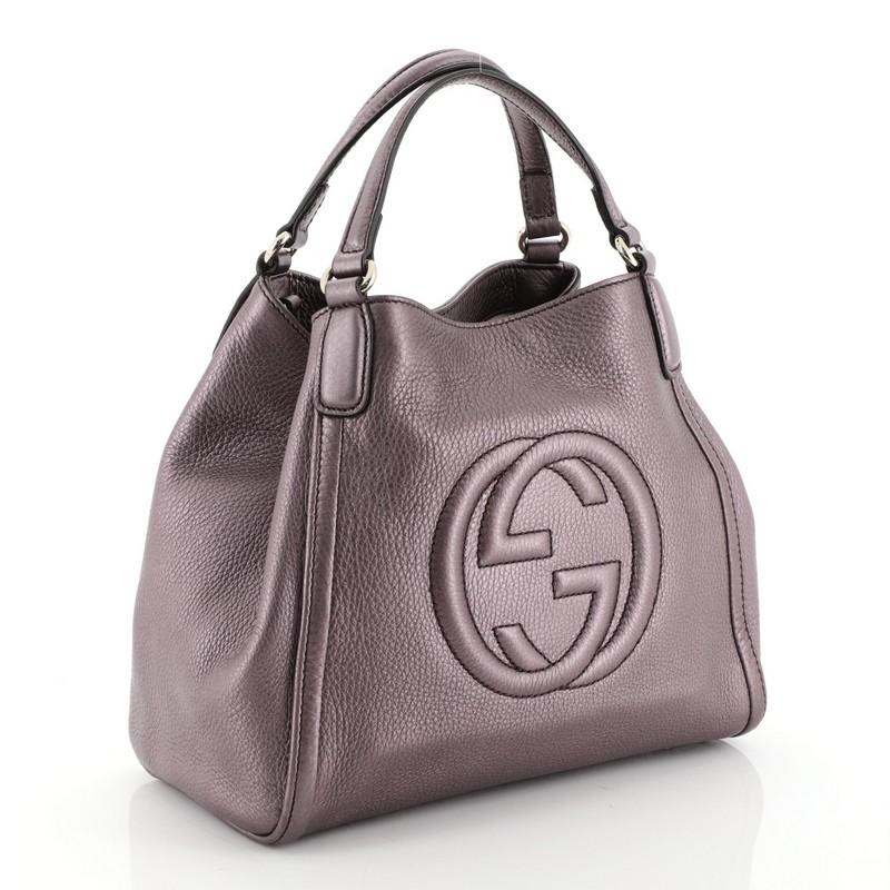 This Gucci Soho Convertible Shoulder Bag Leather Small, crafted from purple leather, features dual flat leather handles, interlocking Gucci logo stitched in front, and gold-tone hardware. Its hook closure opens to a neutral fabric interior with zip