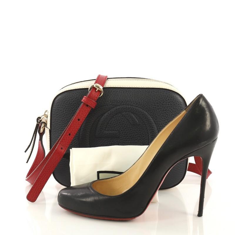 This Gucci Soho Disco Crossbody Bag Leather Small, crafted in navy, red, and white leather, features an adjustable leather strap, tassel zip pull, and gold-tone hardware. Its zip closure opens to a beige canvas interior with slip pockets. **Note: