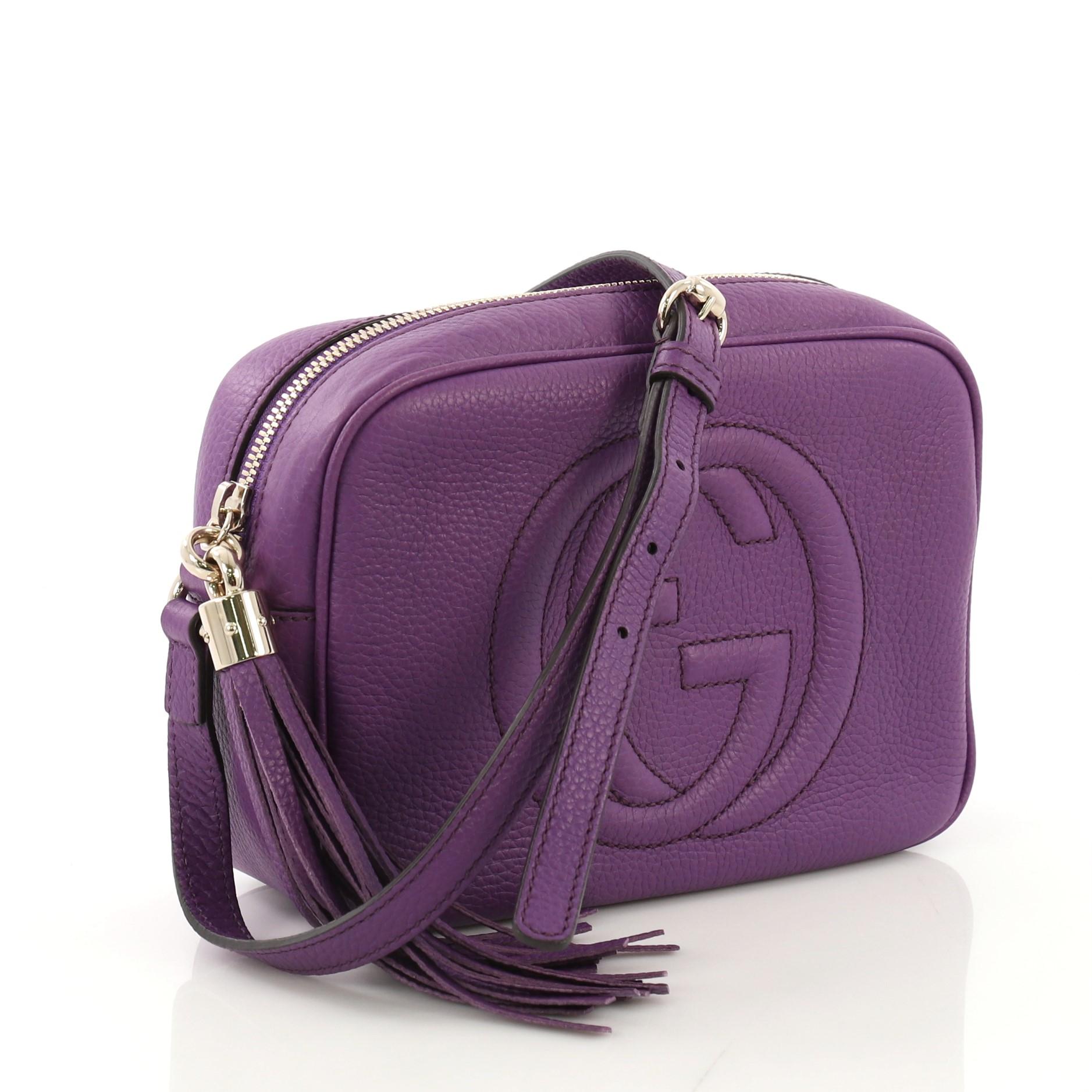 This Gucci Soho Disco Crossbody Bag Leather Small, crafted in purple leather, features an adjustable leather strap, tassel zip pull, and gold-tone hardware. Its zip closure opens to a beige fabric interior with slip pockets. 

Estimated Retail