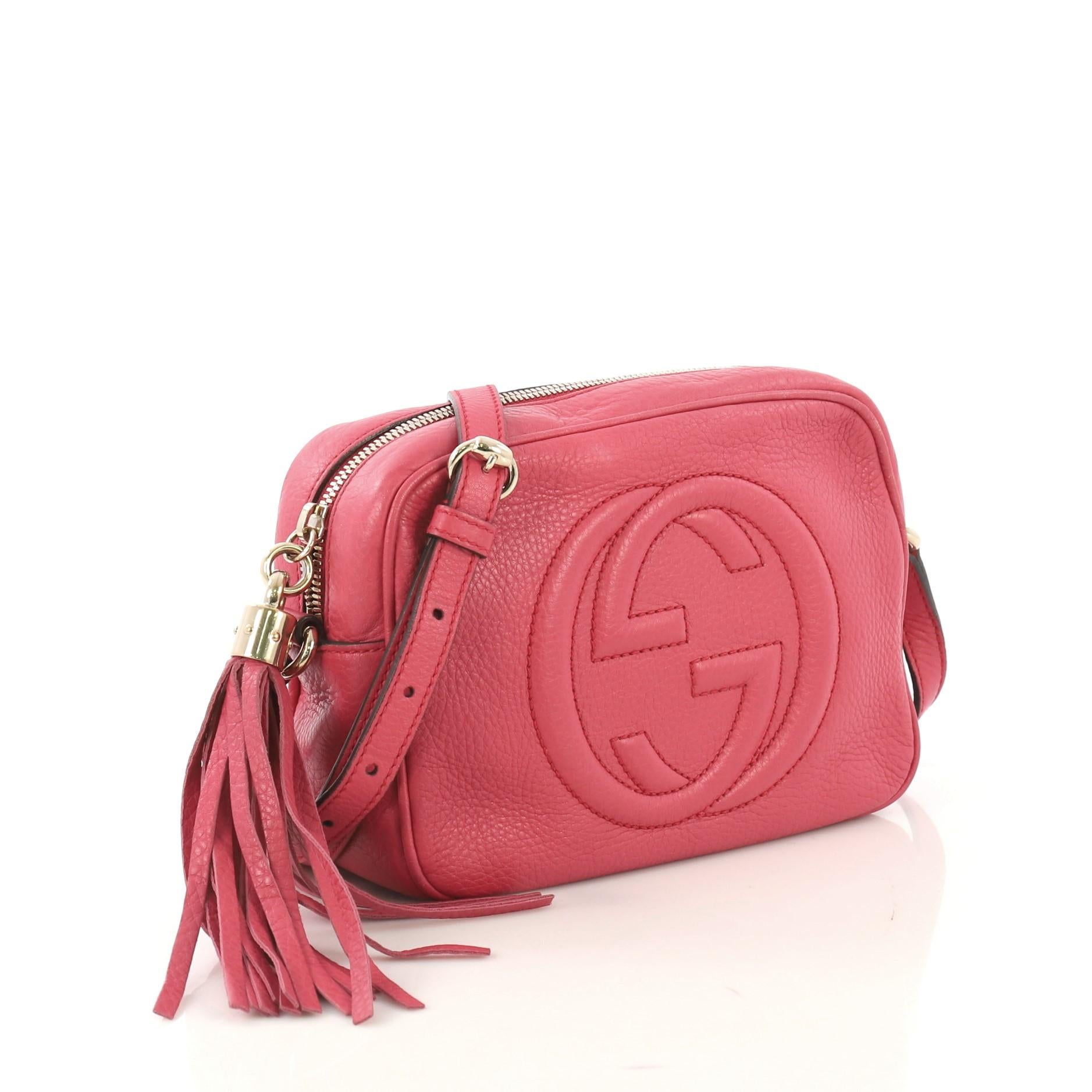 This Gucci Soho Disco Crossbody Bag Leather Small, crafted in pink leather, features an adjustable leather strap, tassel zip pull, and gold-tone hardware. Its zip closure opens to a beige fabric interior with slip pockets. 

Estimated Retail Price: