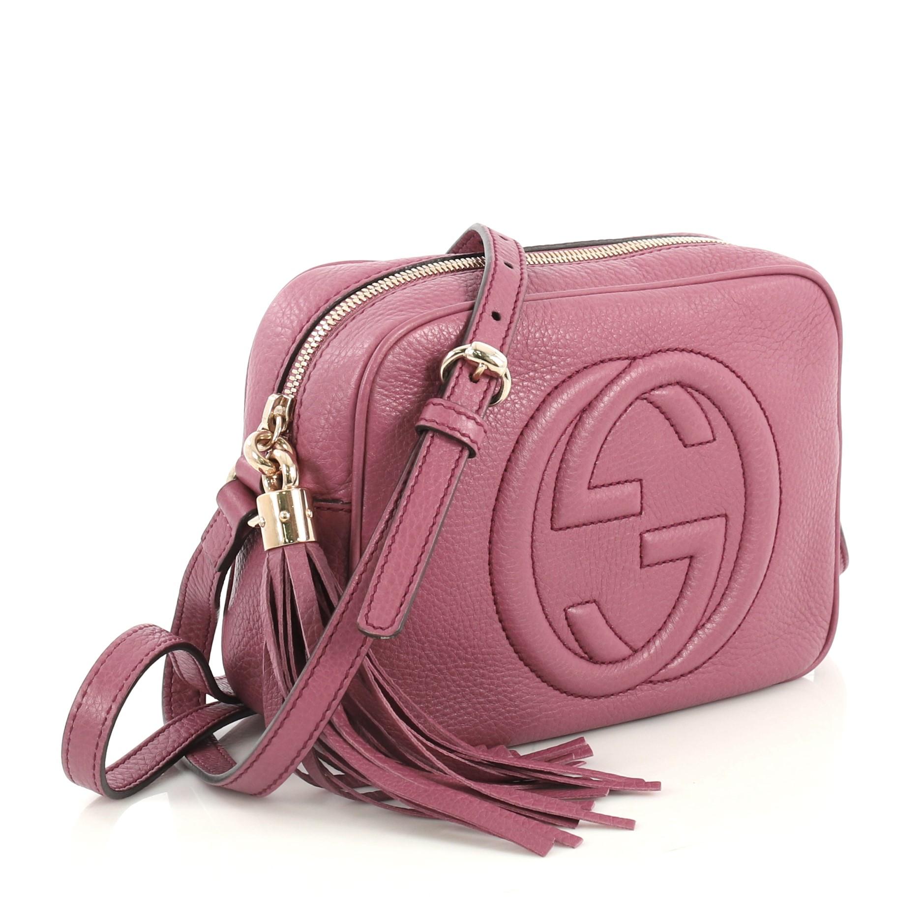 This Gucci Soho Disco Crossbody Bag Leather Small, crafted in purple leather, features an adjustable leather strap, tassel zip pull, and gold-tone hardware. Its zip closure opens to a neutral canvas and fabric interior with slip pockets. 

Estimated