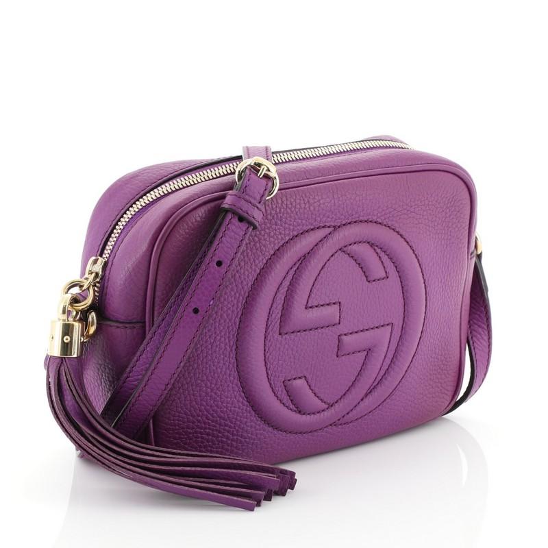 This Gucci Soho Disco Crossbody Bag Leather Small, crafted in purple leather, features an adjustable leather strap, tassel zip pull, and gold-tone hardware. Its zip closure opens to a neutral fabric interior with slip pockets. 

Estimated Retail