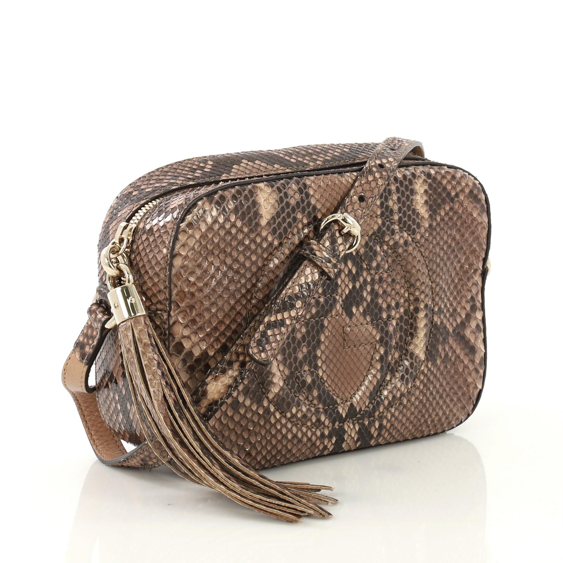 This Gucci Soho Disco Crossbody Bag Python Small, crafted in genuine brown python, features an adjustable strap, tassel zip pull, and gold-tone hardware. Its zip closure opens to a beige fabric interior with slip pockets. This item can only be