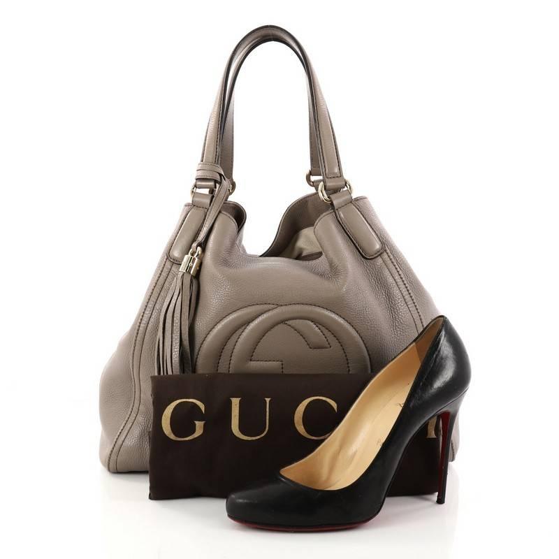 This authentic Gucci Soho Shoulder Bag Leather Medium is simple yet stylish in design. Crafted in taupe leather, this bag features dual-flat leather handles, protective base studs, signature interlocking Gucci logo stitched in front and gold-tone