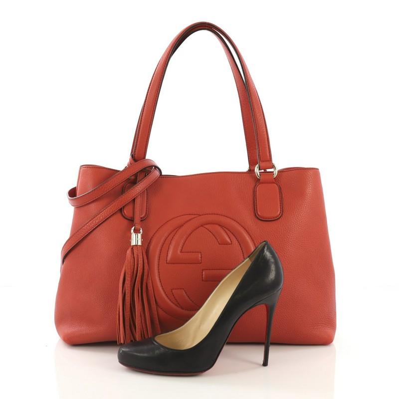 This Gucci Soho Working Tote Leather Medium, crafted from burnt orange leather, features dual tall handles, stitched interlocking GG logo, protective base studs, and gold-tone hardware. Its wide open top opens to a beige fabric interior with a