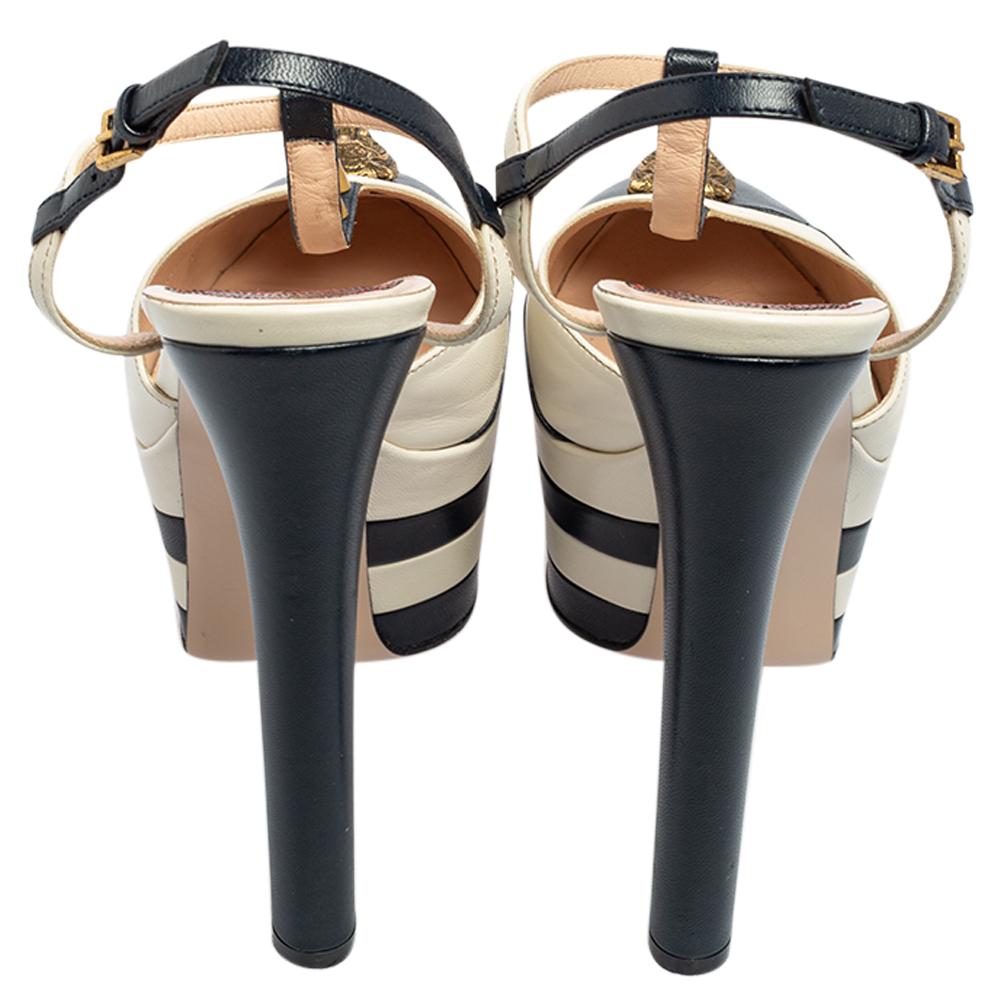 You're all set to touch the skies with these towering Angel sandals from Gucci. Shimmering in dual shades, these sandals are crafted from leather and feature a chic silhouette. They flaunt round toes with cutouts and a tiger head, spikes on the