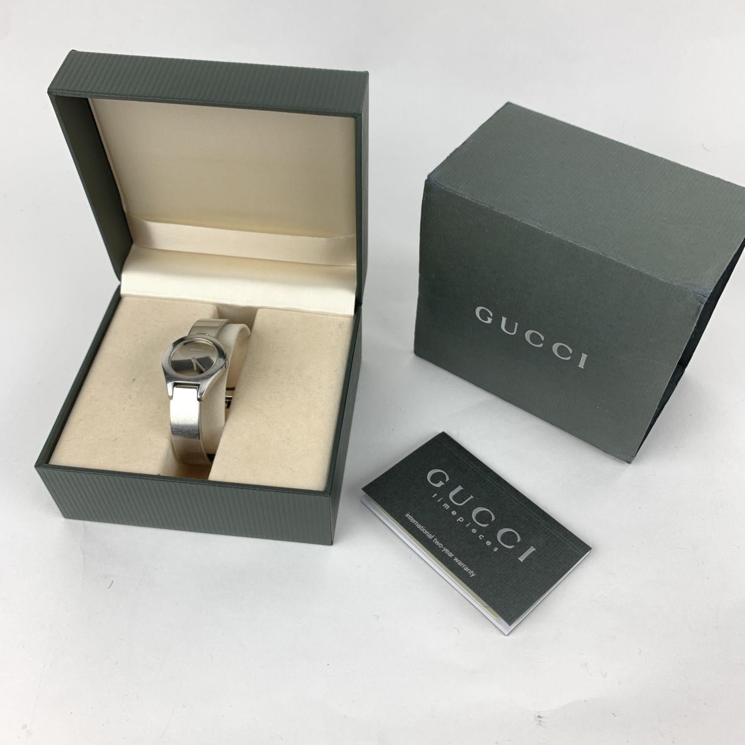 Beautiful Wristwatch by GUCCI, mod. 6700 L. Crafted on stainless steel Black dial. Gucci baton hour, minute & second hands. Quartz movement. Stainless steel round case (width: 26 mm). Belt buckle band. Sapphire crystal. 'GUCCI' and 'Swiss made'