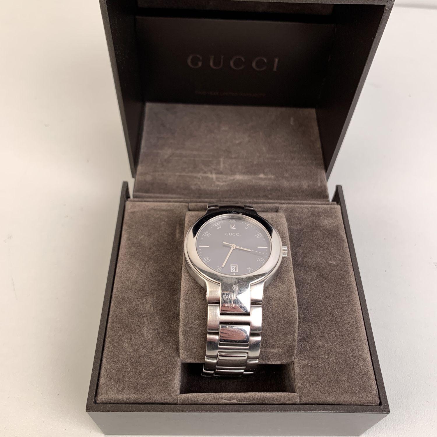 Gucci stainless steel wrist watch, mod. 8900 M. Stainless steel case. Black Dial. Date at 6 o'clock. Sapphire crystal. Swiss Made Quartz movement. Gucci written on face. Arabic numbers. Water Resistant to 3atm. Deployant Clasp. Swiss Made. Will fit