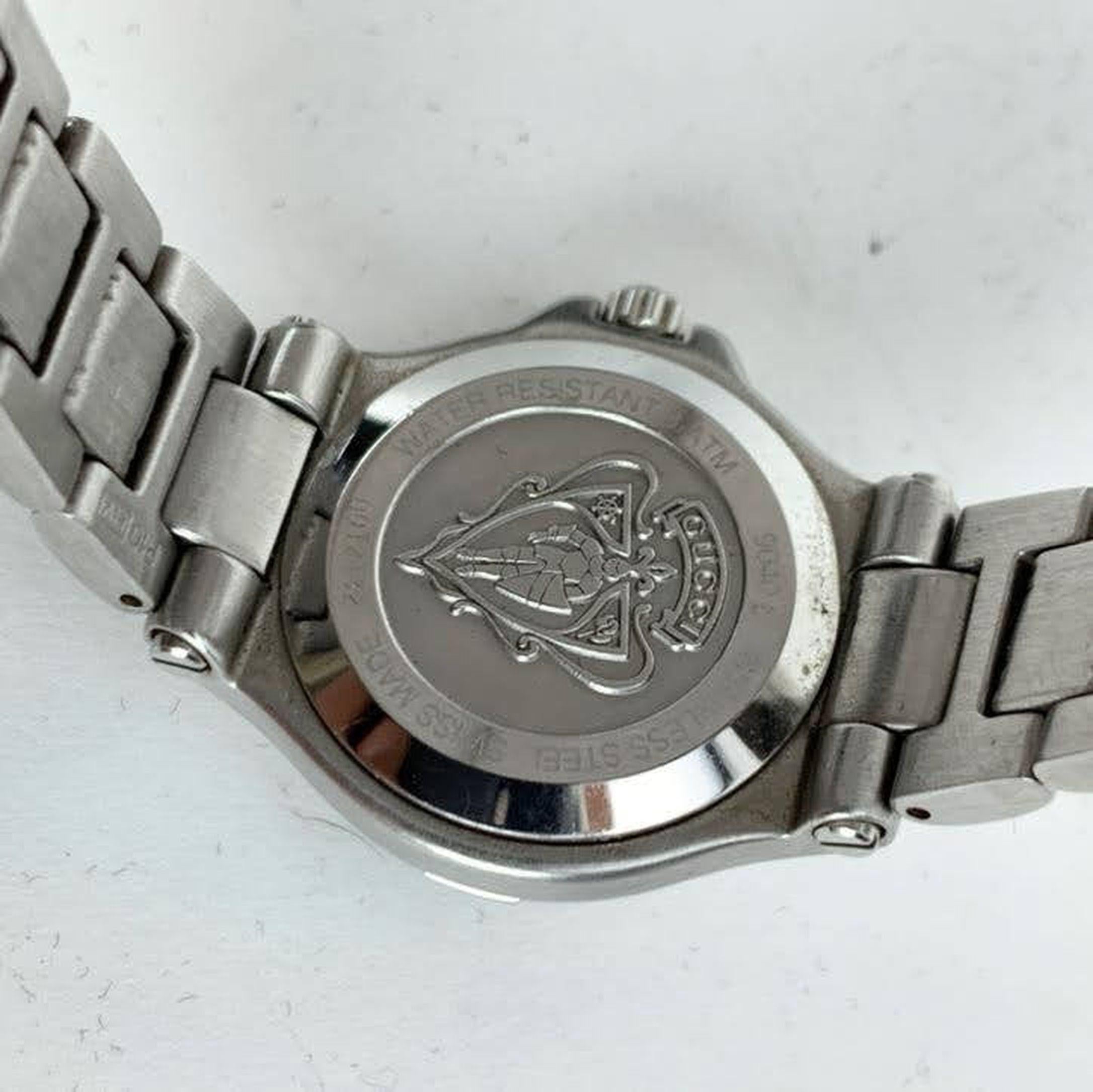 Gucci stainless steel wrist watch, mod. 9040 L. Stainless steel case. Black Dial. Date at 6 o'clock. Sapphire crystal. Swiss Made. Quartz movement. Gucci written on face. Gucci crest on the reverse of the case. GG logo engraved on the clasp. Water