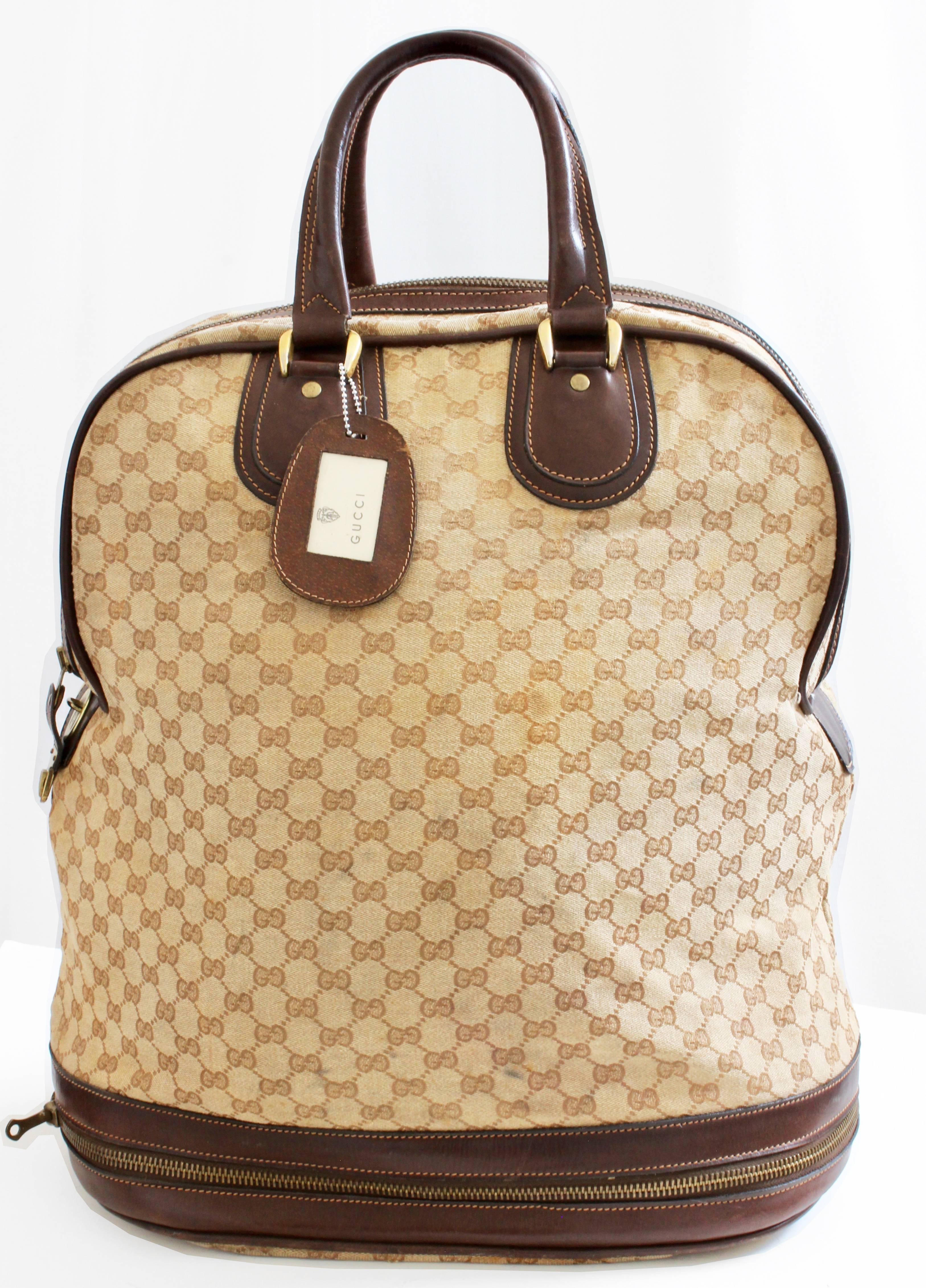 Travel in style with this unique keepall or steamer bag from Gucci, likely made in the 1970s.  It features Gucci's signature Supreme canvas with leather trim and a zippered expandable section at the bottom, which provides an additional 9 inches of