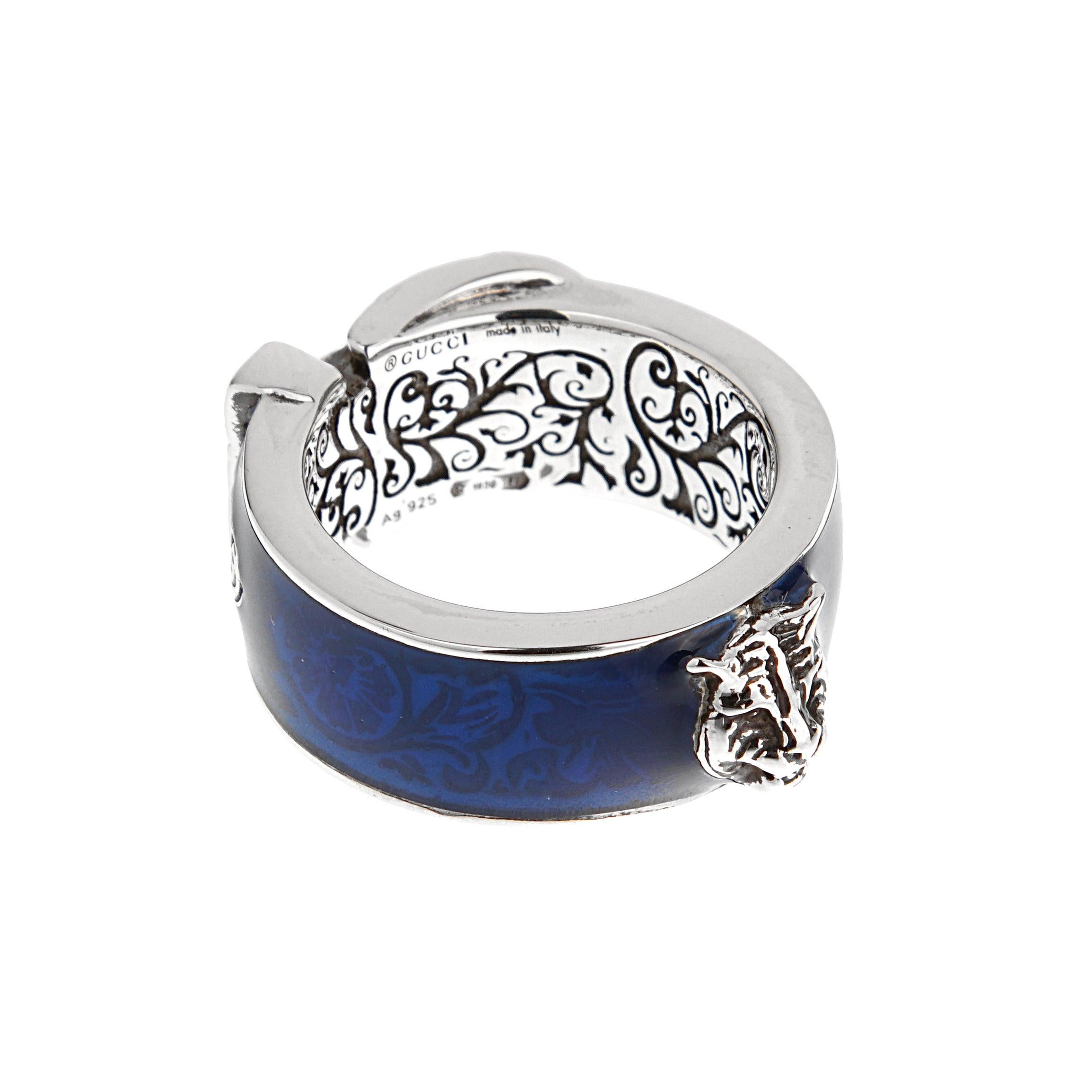 Un anillo distintivo de Gucci, elaborado en plata de ley 925. Presenta una incrustación de esmalte azul.

Marca: Gucci
Material: Plata de ley
Pureza del metal: 925
Característica principal: Esmalte azul
Diseño: Hebilla con volutas
Estado: Sin usar