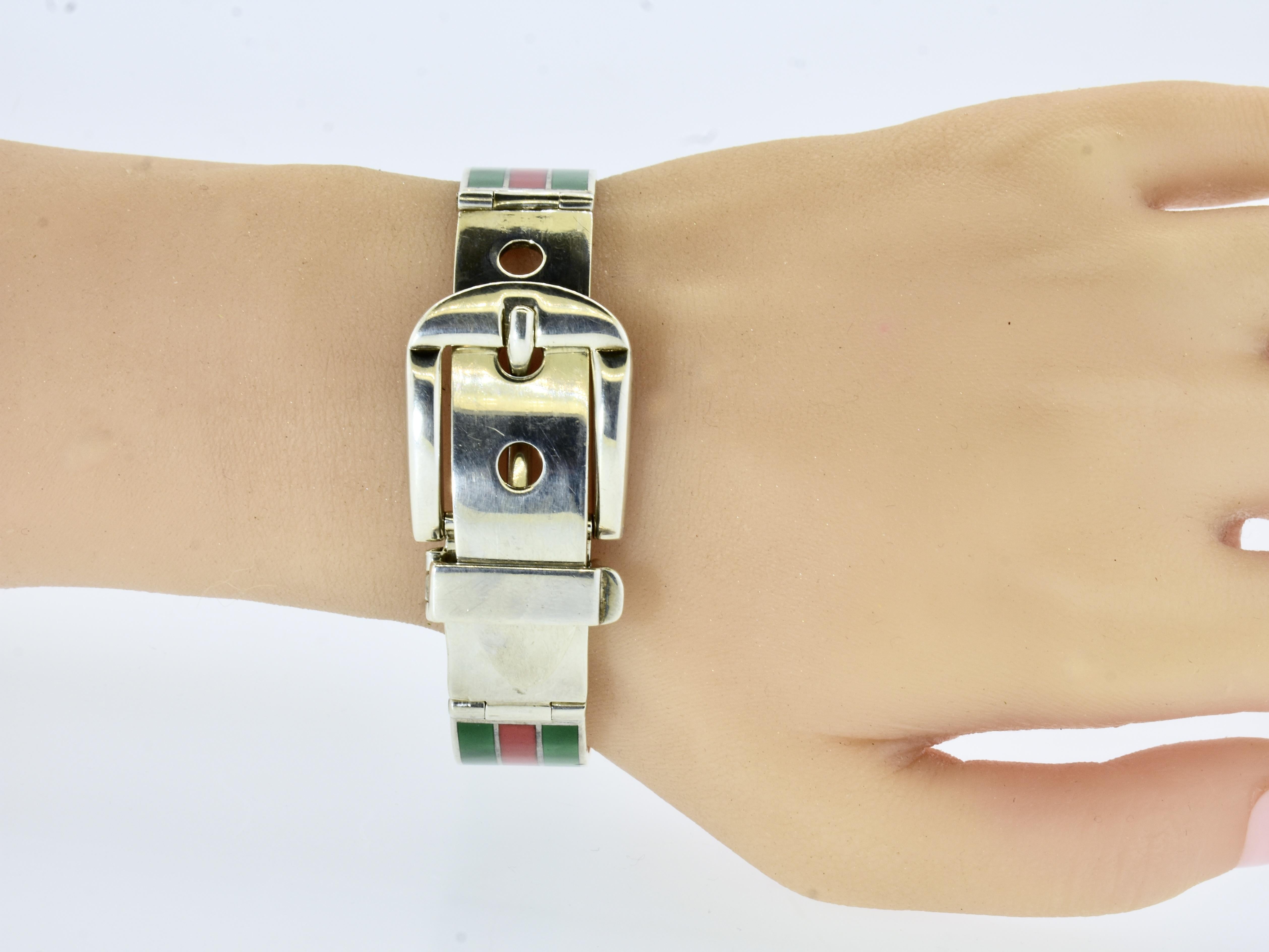 Gucci sterling silver bangle bracelet. Crafted in 1970, this contemporary piece showcases the iconic design sensibilities of the Italian fashion house. The bracelet features a sleek, polished sterling silver band adorned with vibrant green and red