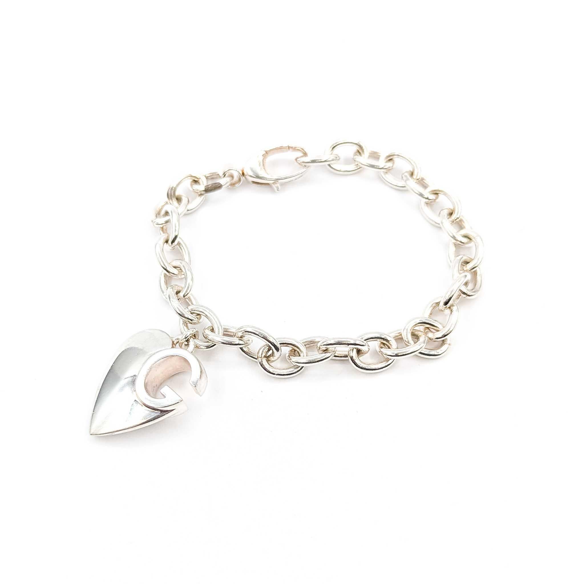 Questo autentico bracciale Gucci è realizzato in argento massiccio e presenta audaci maglie Rolo da 8,5 mm, creando un pezzo d'effetto con un peso notevole di 37 grammi. Al centro è appeso l'iconico charm a forma di cuore di Gucci, ornato dal motivo