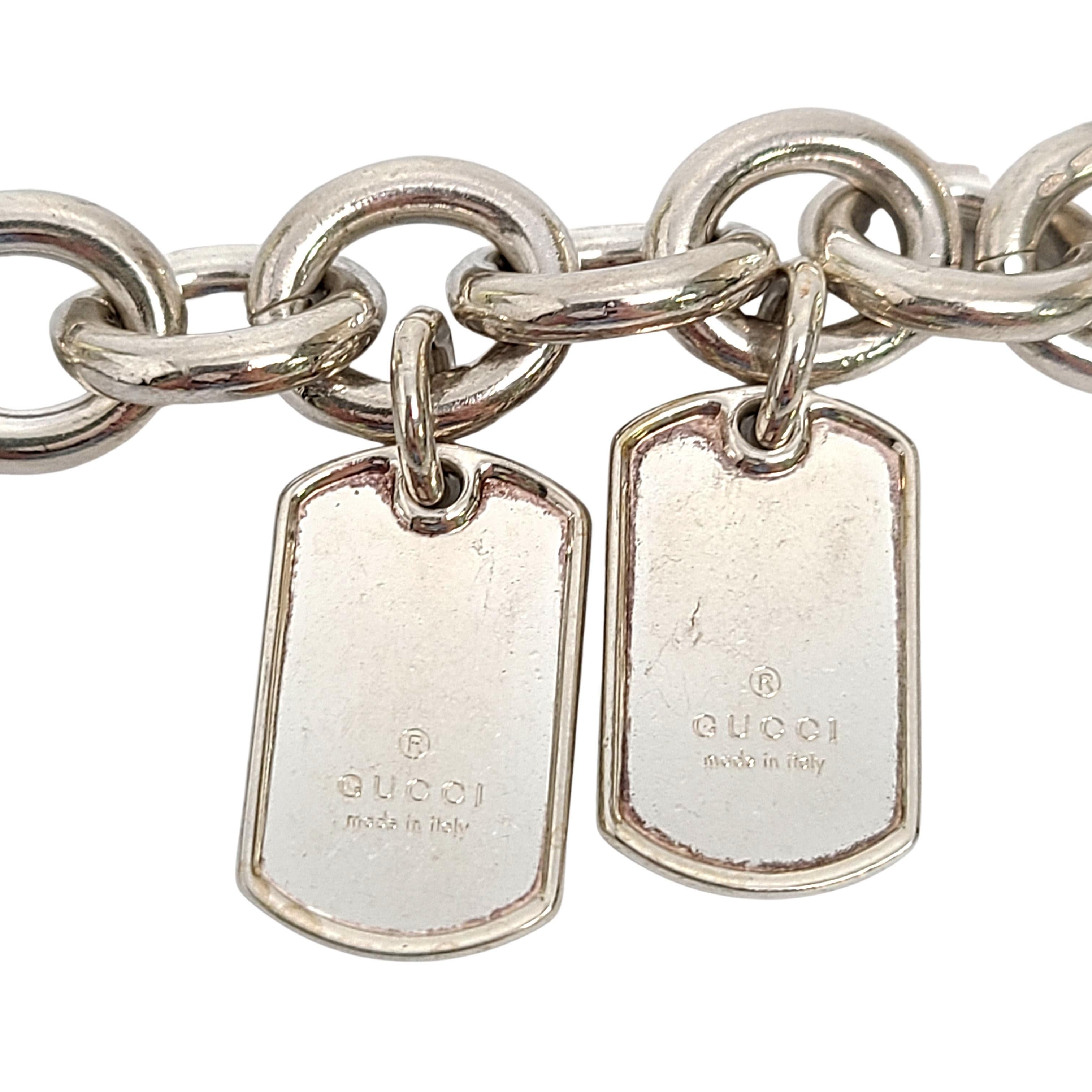 Sterling silver rolo link bracelet with 2 GUCCI dog tags by Gucci.

Heavy and substantial smooth oval shaped rolo link bracelet with 2 