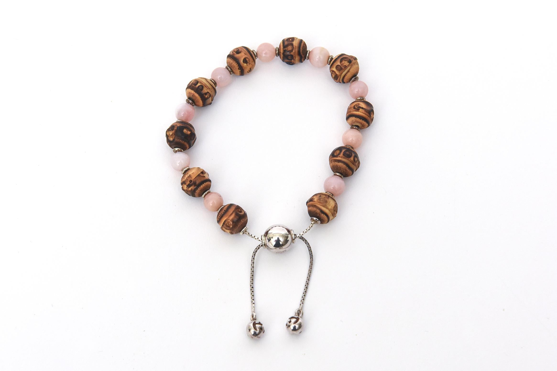 This vintage Italian Gucci small bracelet is part sterling silver and the beads are a combination of a pink gemstone that looks like rose quartz infused with a bamboo like stone bead. it is narrow and should be coupled with other bracelets of Gucci