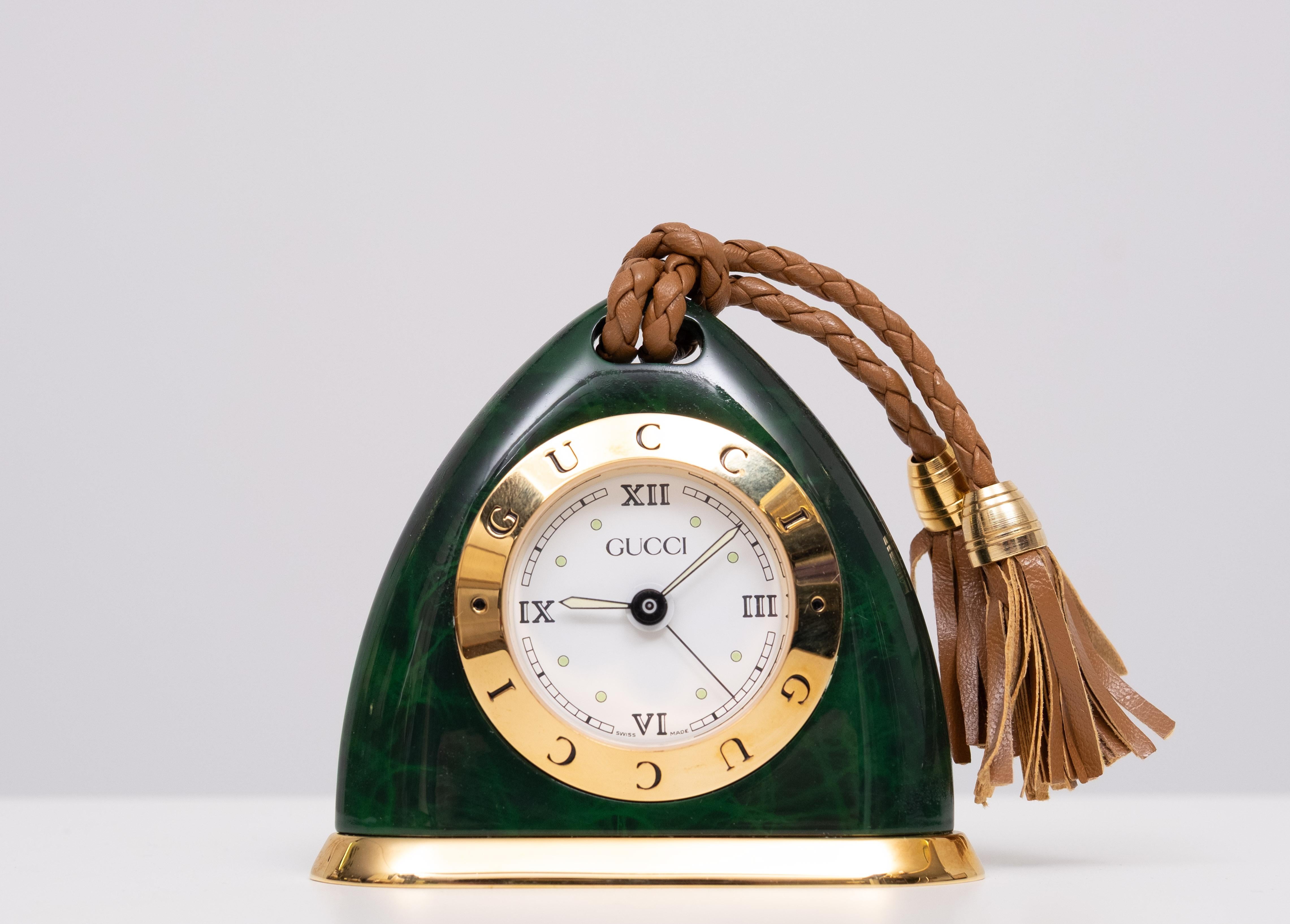 A GUCCI Swiss made Alarm CLOCK, of triangular form, in a simulated malachite and gold Coloured case, stamped to base GUCCI REGISTERED MODEL, No.    New in box .
comes with the Two original boxes and papers . which makes it a great gift.