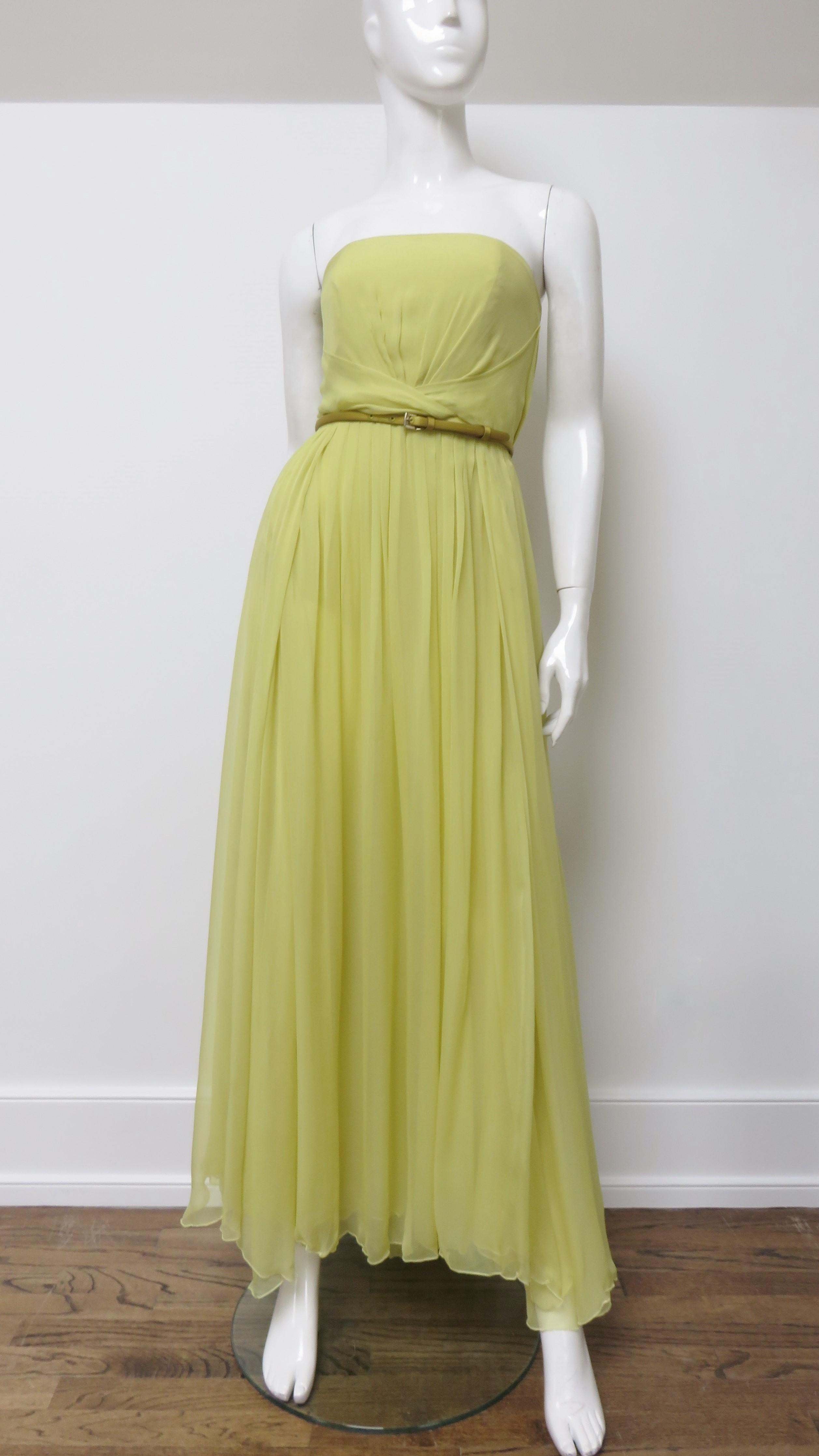 A spectacular fine silk gown with matching wrap, belt, and hot pants in shades of yellow from Gucci. The strapless gown has an inner boned corset and waist detailing. The double layer skirt has multiple thigh high slits around it's circumference