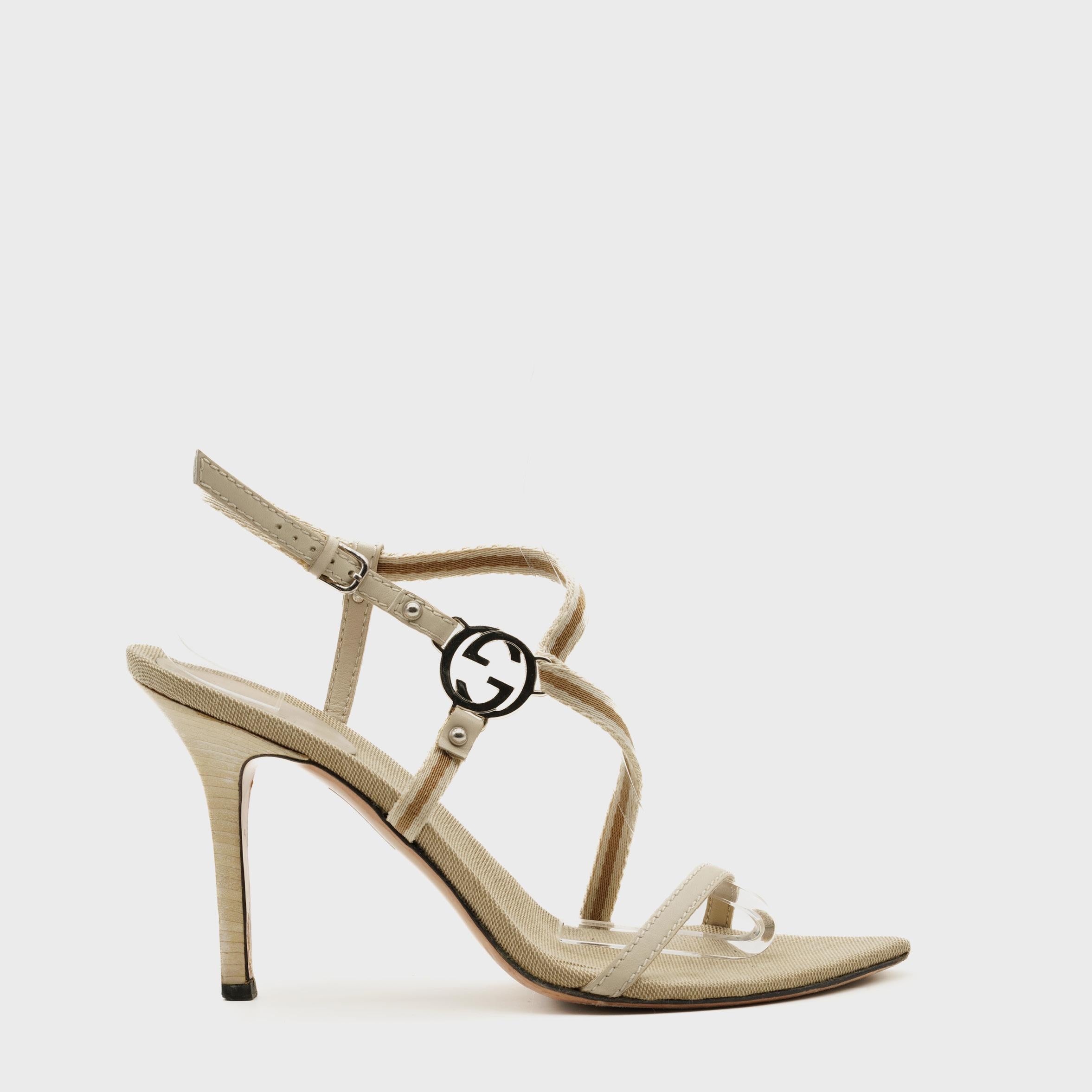 Issues de l'ère Gucci du début des années 2000, ces sandales à brides incarnent le minimalisme sensuel de la maison sous la direction créative de Tom Ford. Confectionnées en Italie, elles sont dotées de fines brides en toile beige bordées de cuir