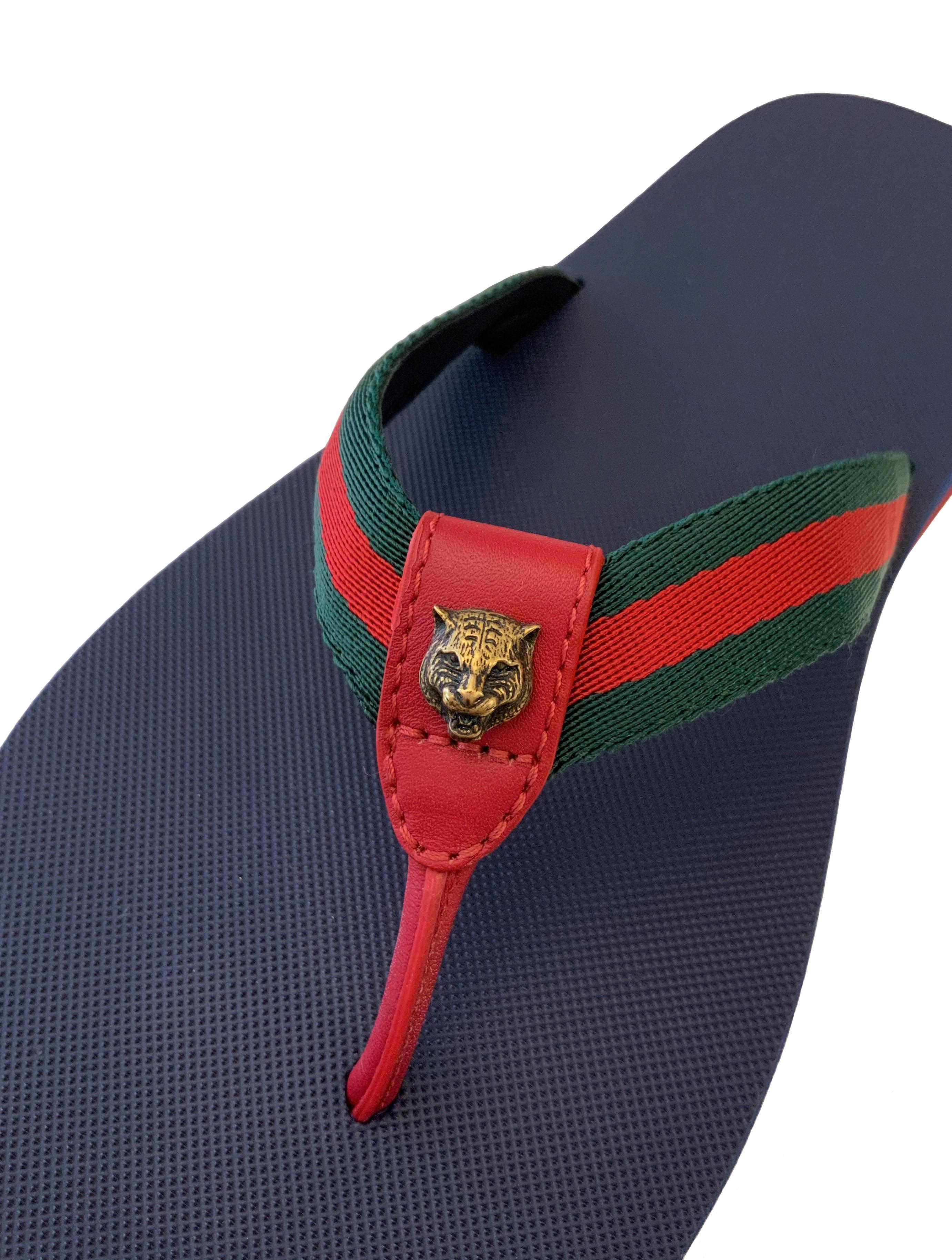 These pre-owned but new flip flops from Gucci feature the house's iconic web canvas, red leather trimming and an antique gold finish tiger head.  
The platform foam sole with its rubber base offers a very comfortable fit.

Material: canvas, leather,