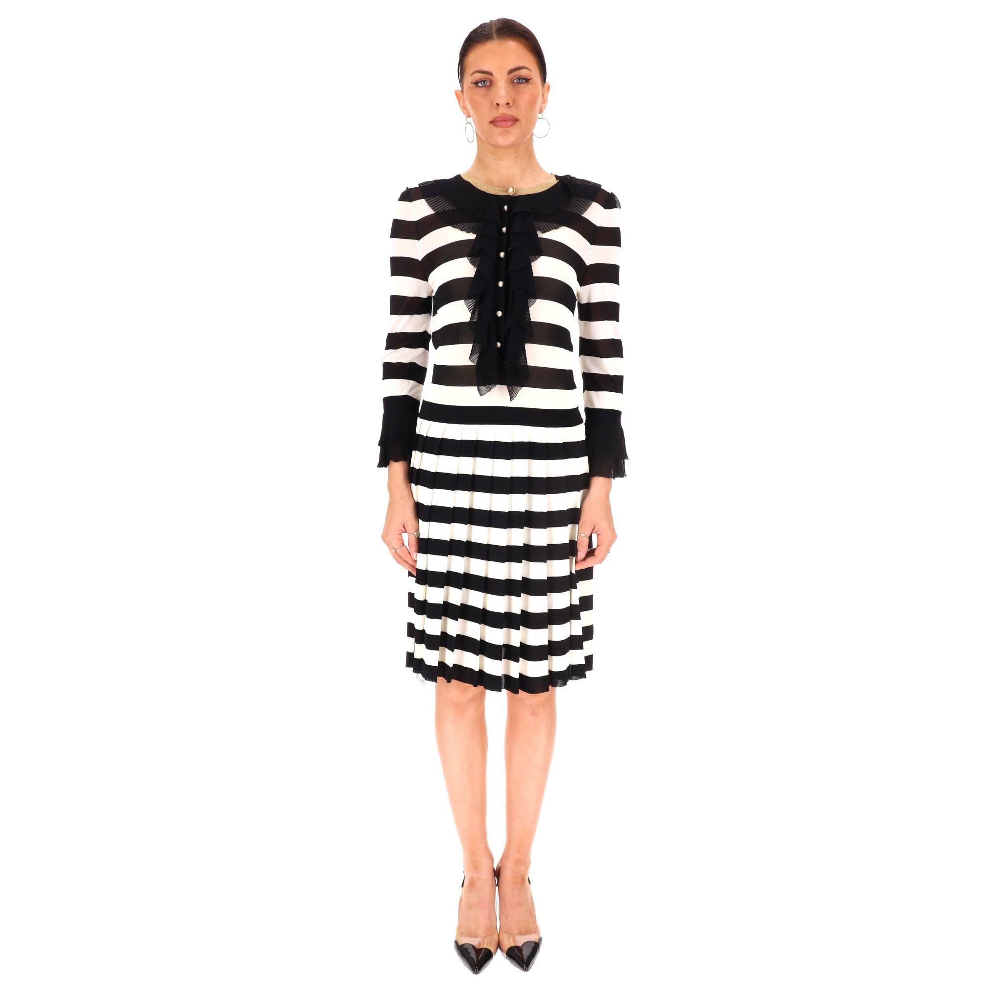 Robe à rayures avec boutons en perles 'GG' de Gucci

Robe noire et blanche à rayures verticales avec boutons perlés à logo GG en or.

Encolure et poignets à volants en dentelle noire.

Jupe plissée et encolure bordée de rayures dorées.

Rrp Approx.