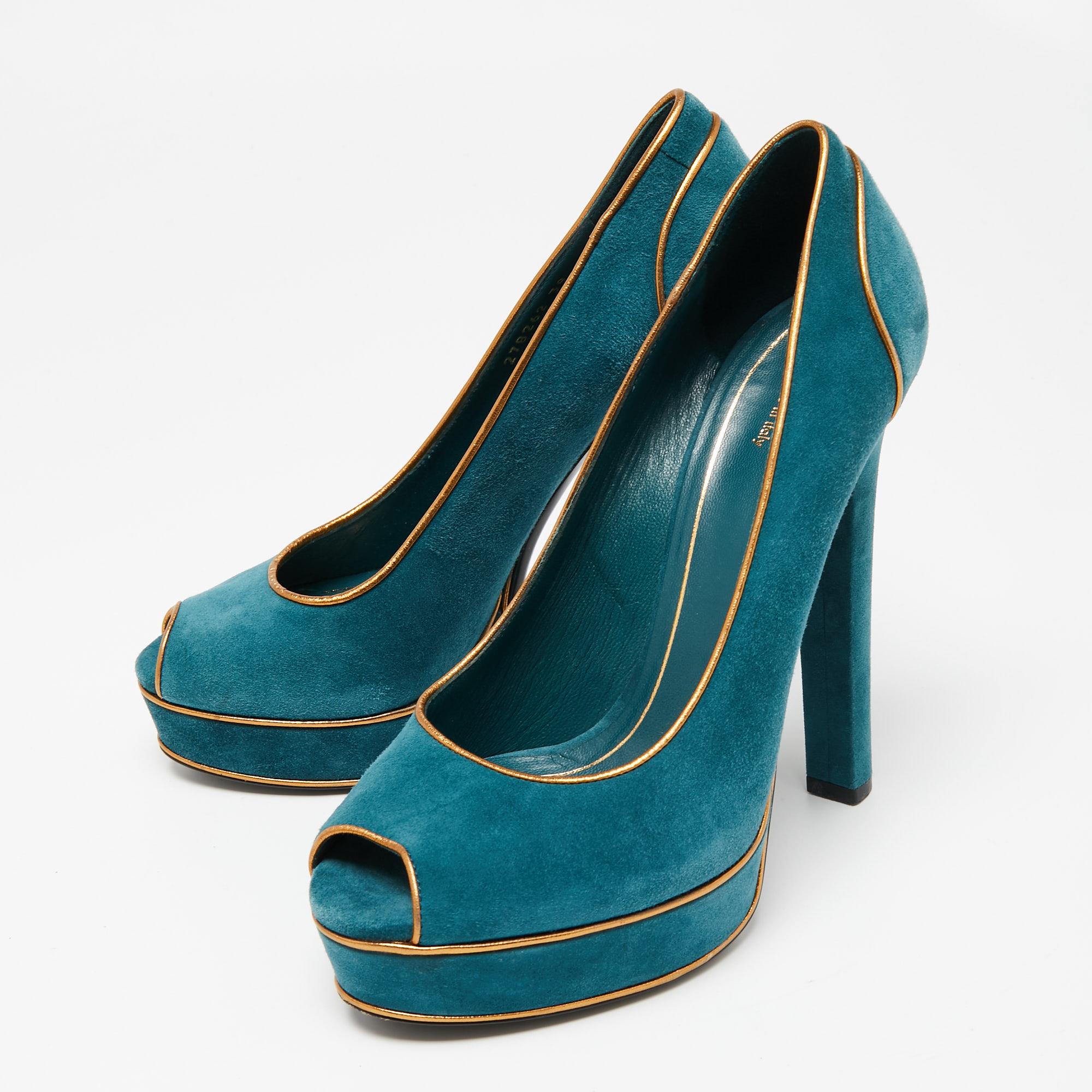 Brimming with unparalleled sophistication, this pair of pumps from Gucci are ready to help you look your best. Rendered in luxurious teal green suede with gold leather piping and flaunting a peep-toe silhouette, these shoes offer comfort with their