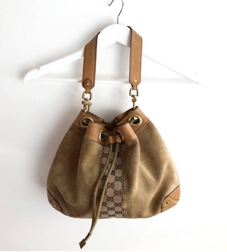 GUCCI suede and leather drawstring bag, gg monogram front and back strip detail, siege drawstring, heavy metal work, interior pocket, leather shoulder strap 

Condition: very good vintage, late 1990s/early 2000s, slight sign of wear on suede, barely