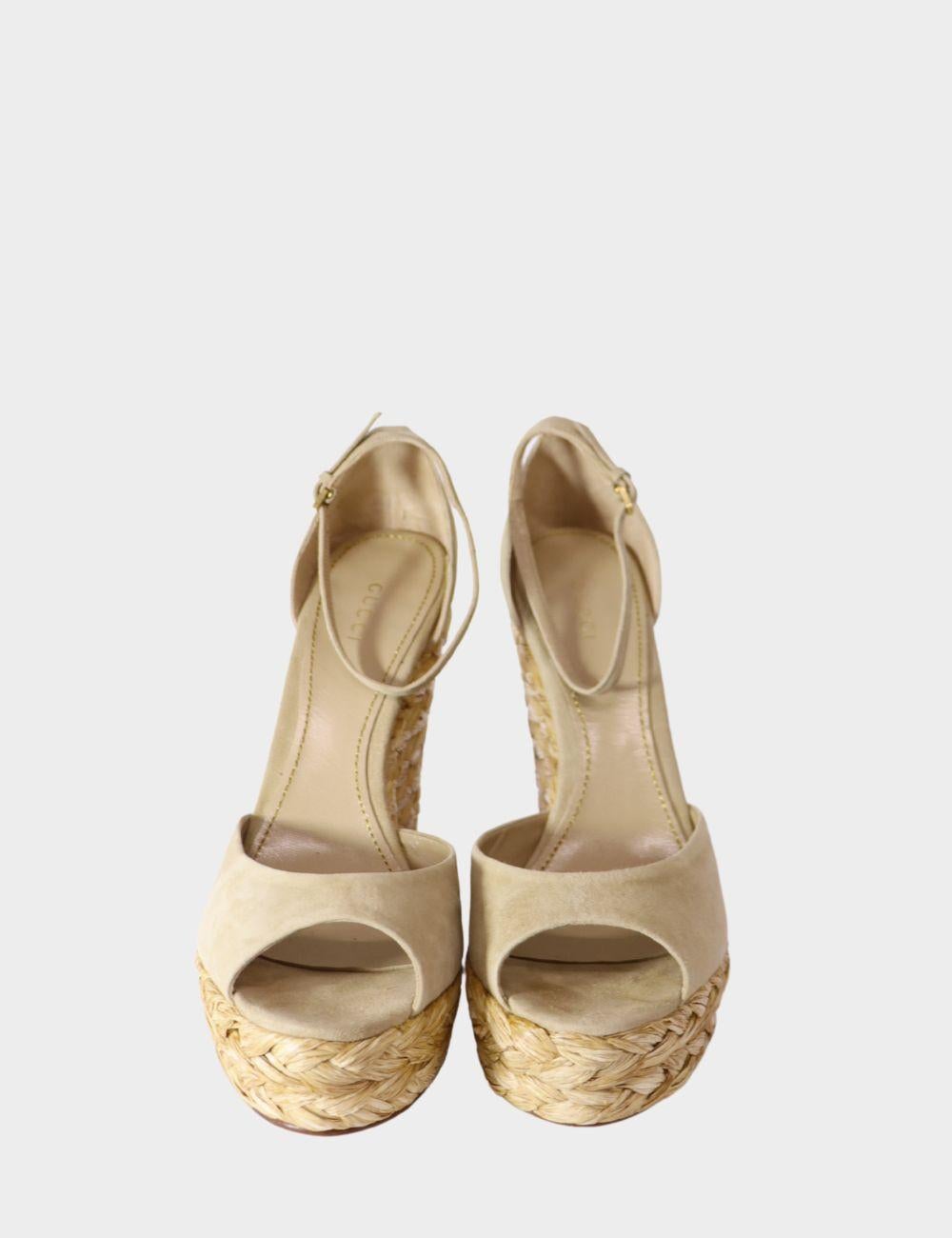 Step into timeless summer style with these Gucci beige suede wedge sandals. Featuring a chic peep toe design and a sturdy ankle strap with adjustable buckle, these sandals are elevated with a natural braided raffia espadrille wedge for a laid-back