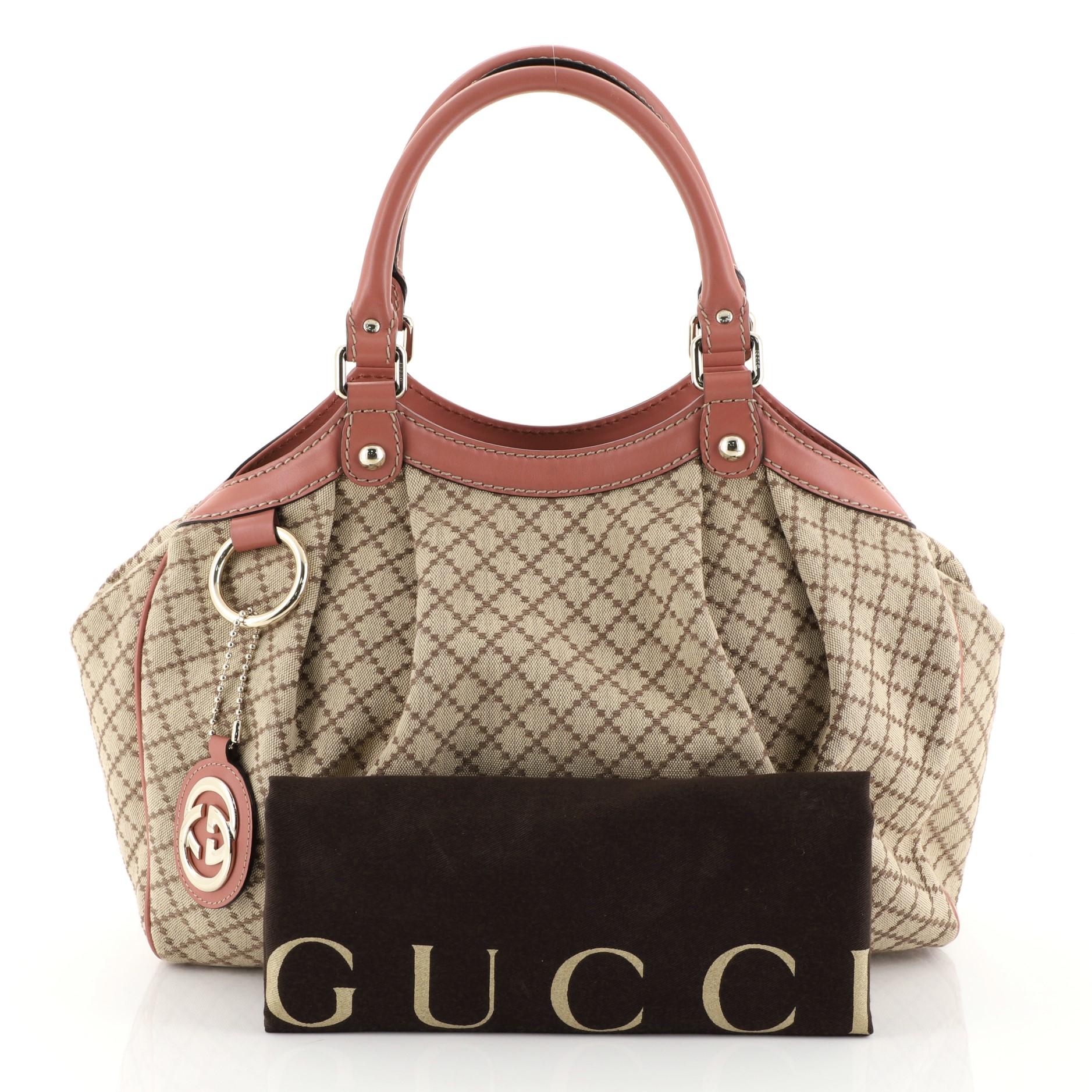 This Gucci Sukey Tote Diamante Canvas Medium, crafted from brown diamante canvas, features dual rolled leather handles, leather trim and gold-tone hardware. Its magnetic snap closure opens to a neutral fabric interior with zip pocket. 

Estimated