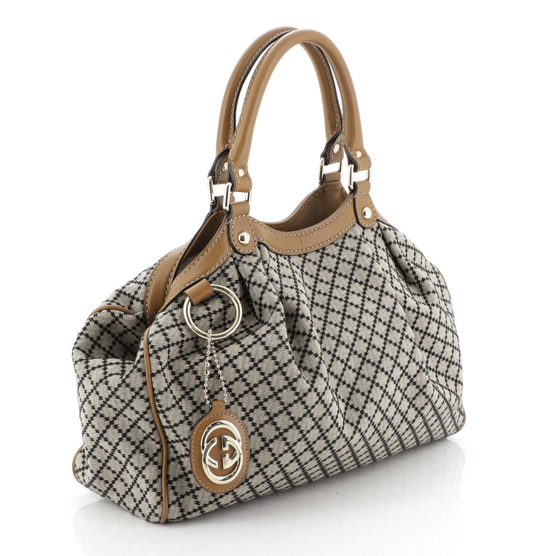 This Gucci Sukey Tote Diamante Canvas Medium, crafted from brown diamante canvas, features dual rolled leather handles, leather trim and gold-tone hardware. Its magnetic snap closure opens to a neutral fabric interior with zip pocket.

Estimated