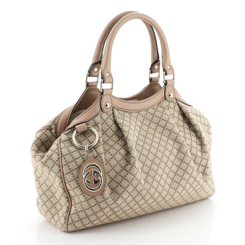 This Gucci Sukey Tote Diamante Canvas Medium, crafted from brown diamante canvas, features dual rolled leather handles and gold-tone hardware. Its magnetic snap closure opens to a neutral fabric interior with zip pocket. 

Estimated Retail Price: