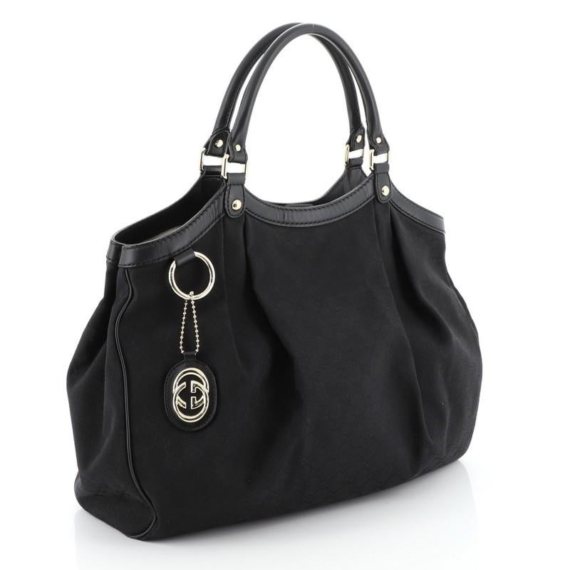 This Gucci Sukey Tote GG Canvas Large, crafted from black GG canvas, features dual rolled leather handles, leather trim, and gold-tone hardware. Its magnetic snap closure opens to a neutral canvas interior with zip pocket. 

Estimated Retail Price: